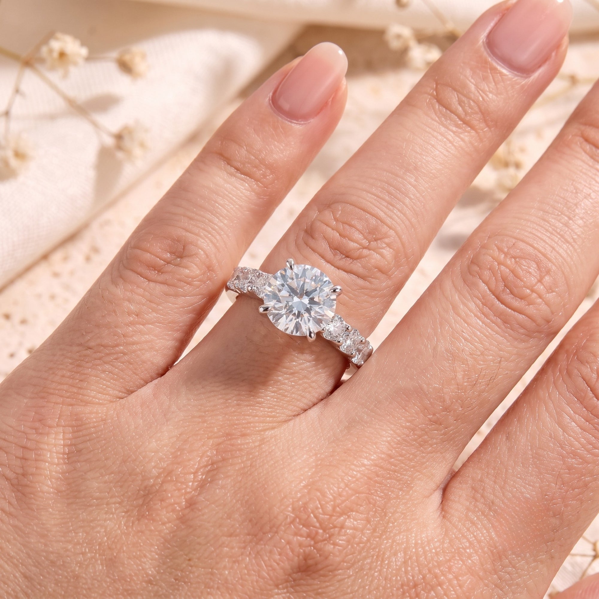 Top-down view of the Julienne sterling silver ring with a round simulated diamond on a hand.