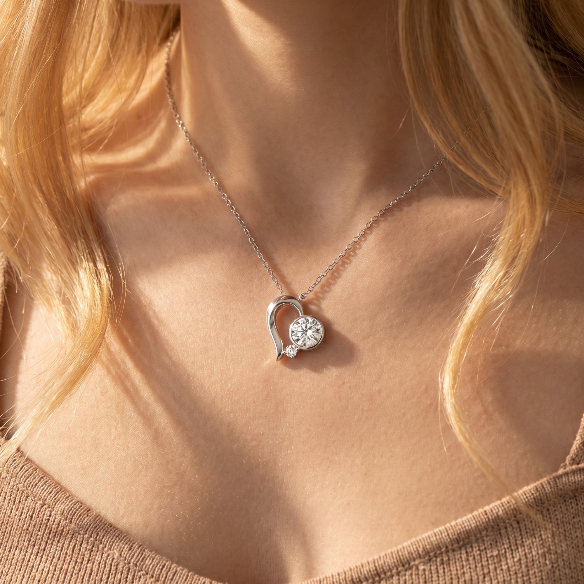 Model wearing the silver Elestina heart necklace with a 6.5mm round moissanite pendant.
