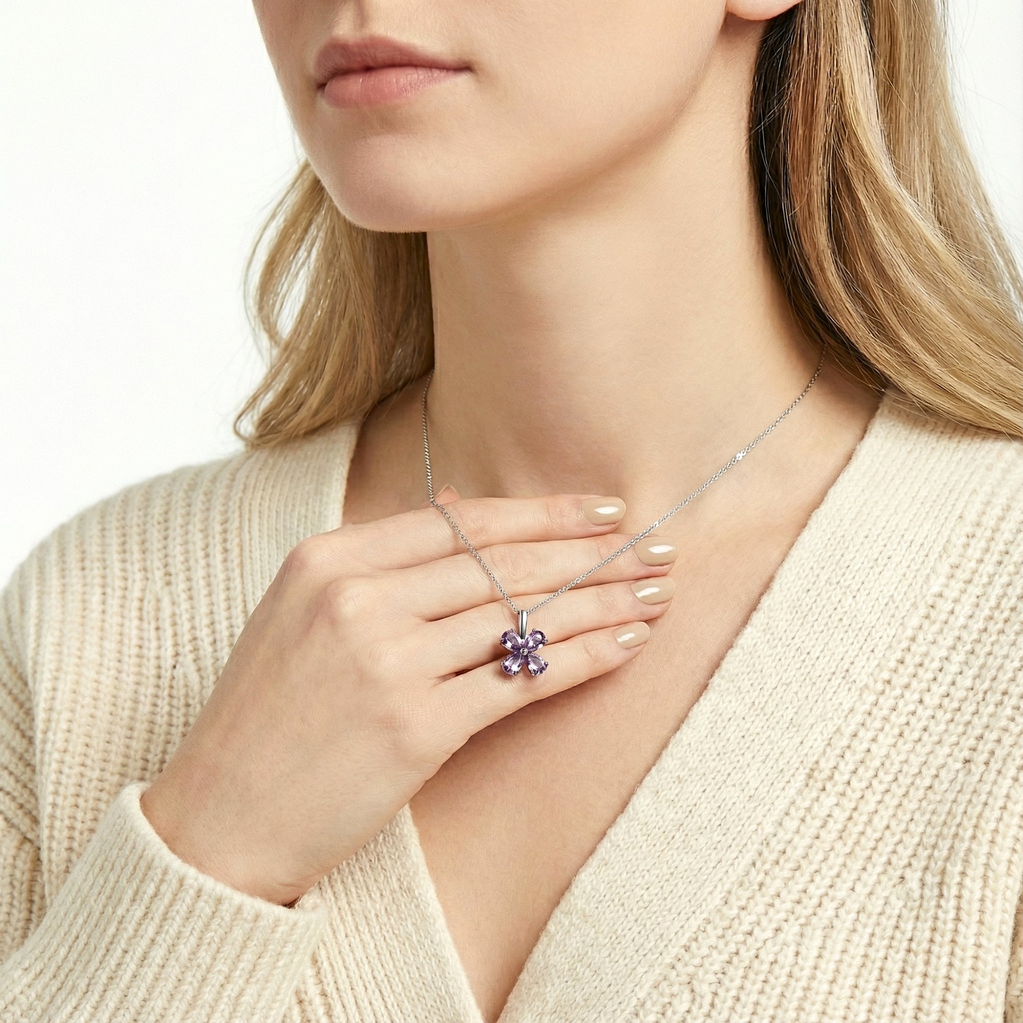 Woman holding the Amity clover pendant to show scale, featuring S925 sterling silver and purple simulated amethysts.