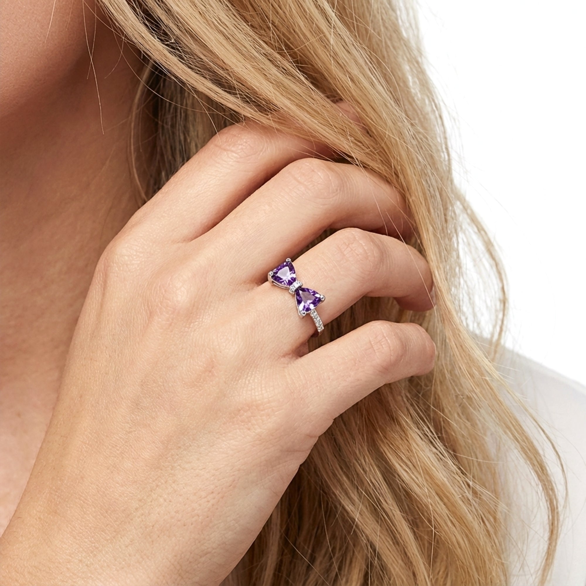 Model wearing the S925 sterling silver bow ring with trillion-cut purple simulated amethyst stones.