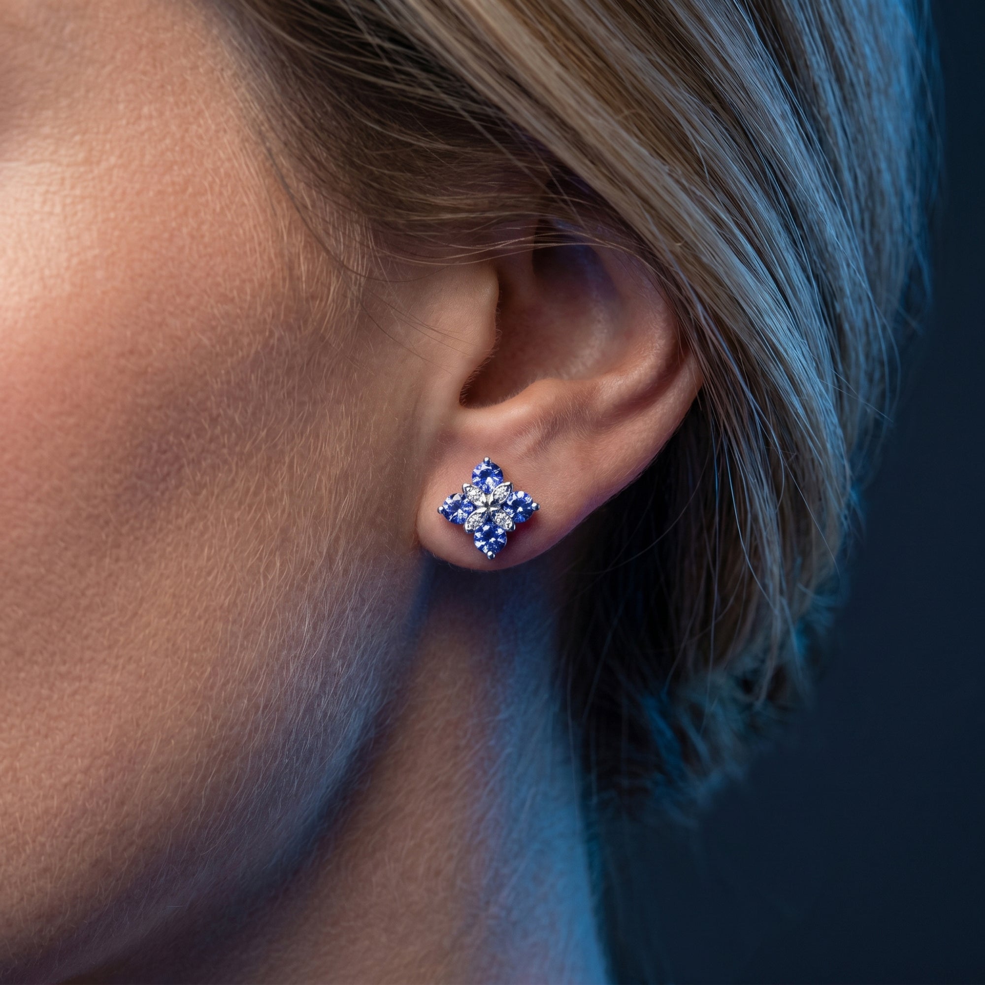 Detailed view of a natural tanzanite flower cluster earring worn by a model.