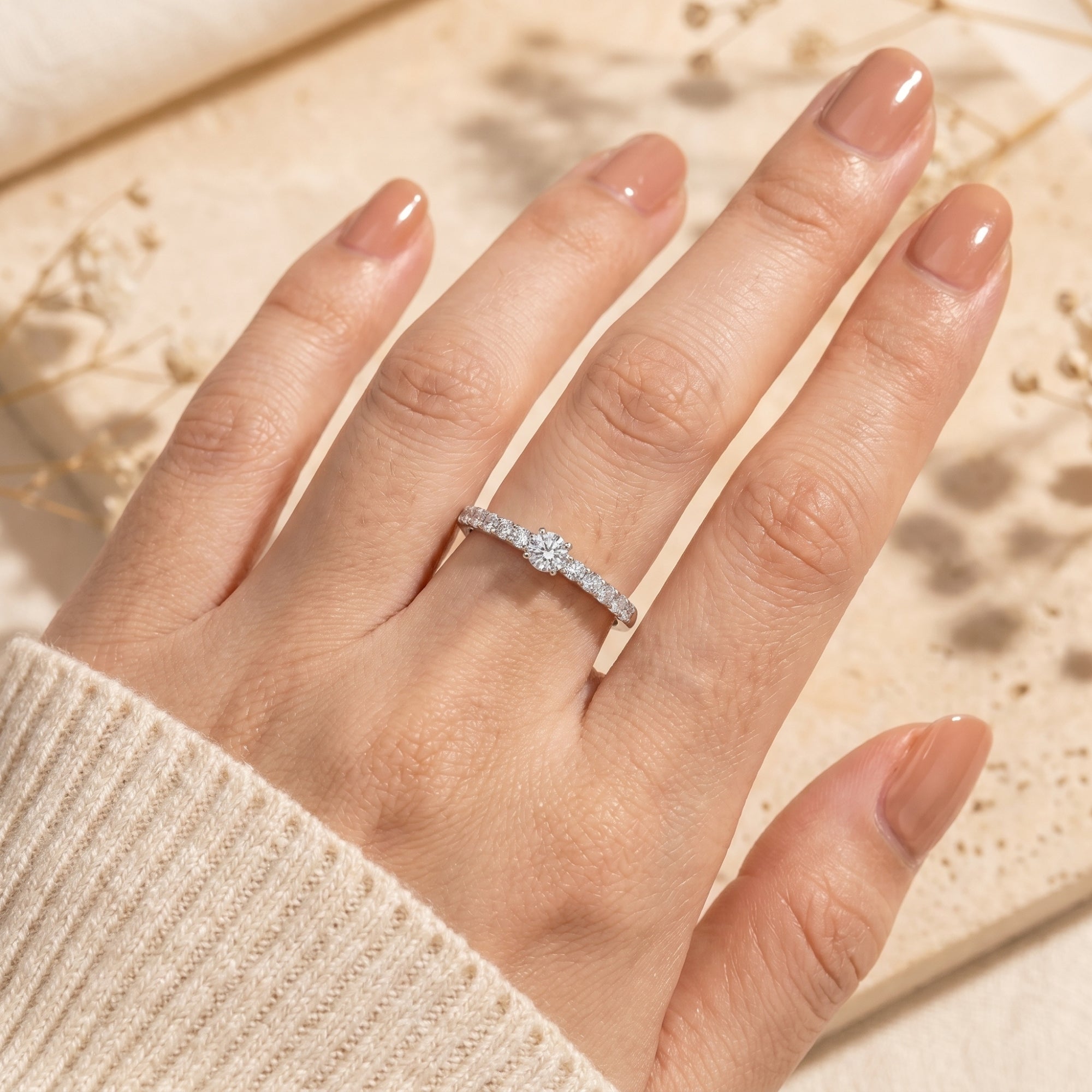 Top view of the Saphirelle moissanite ring on a finger showing the brilliant round center stone.