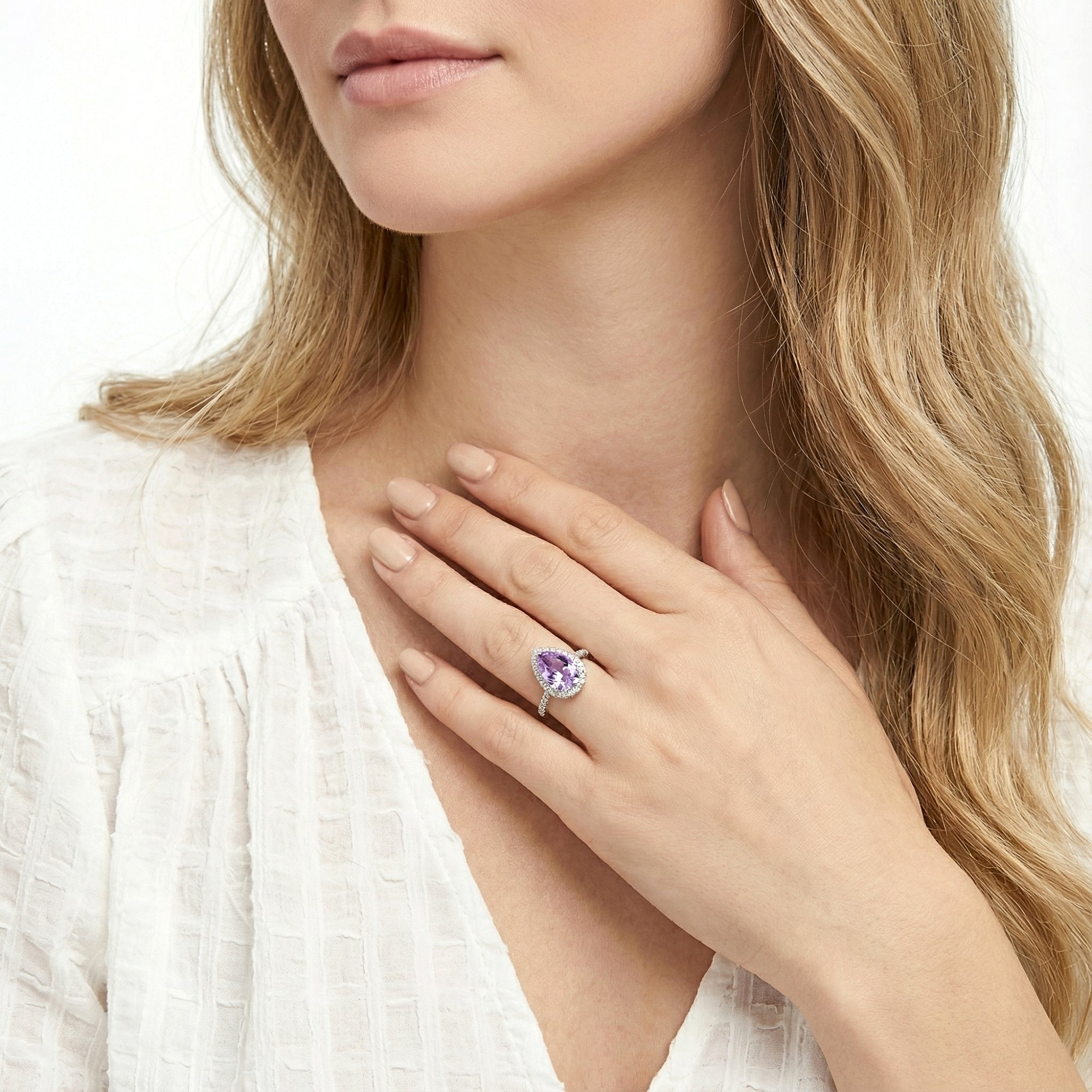 Lifestyle view of a woman wearing the Odette teardrop simulated amethyst ring in S925 sterling silver.