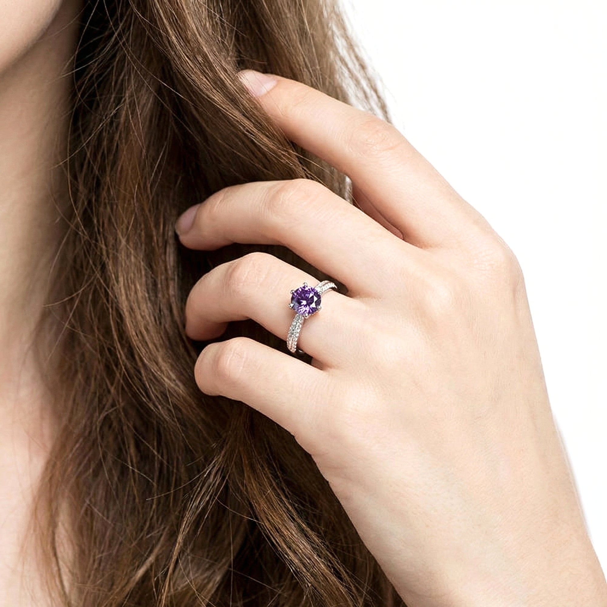 Woman's hand wearing the round-cut purple simulated amethyst solitaire ring in sterling silver.