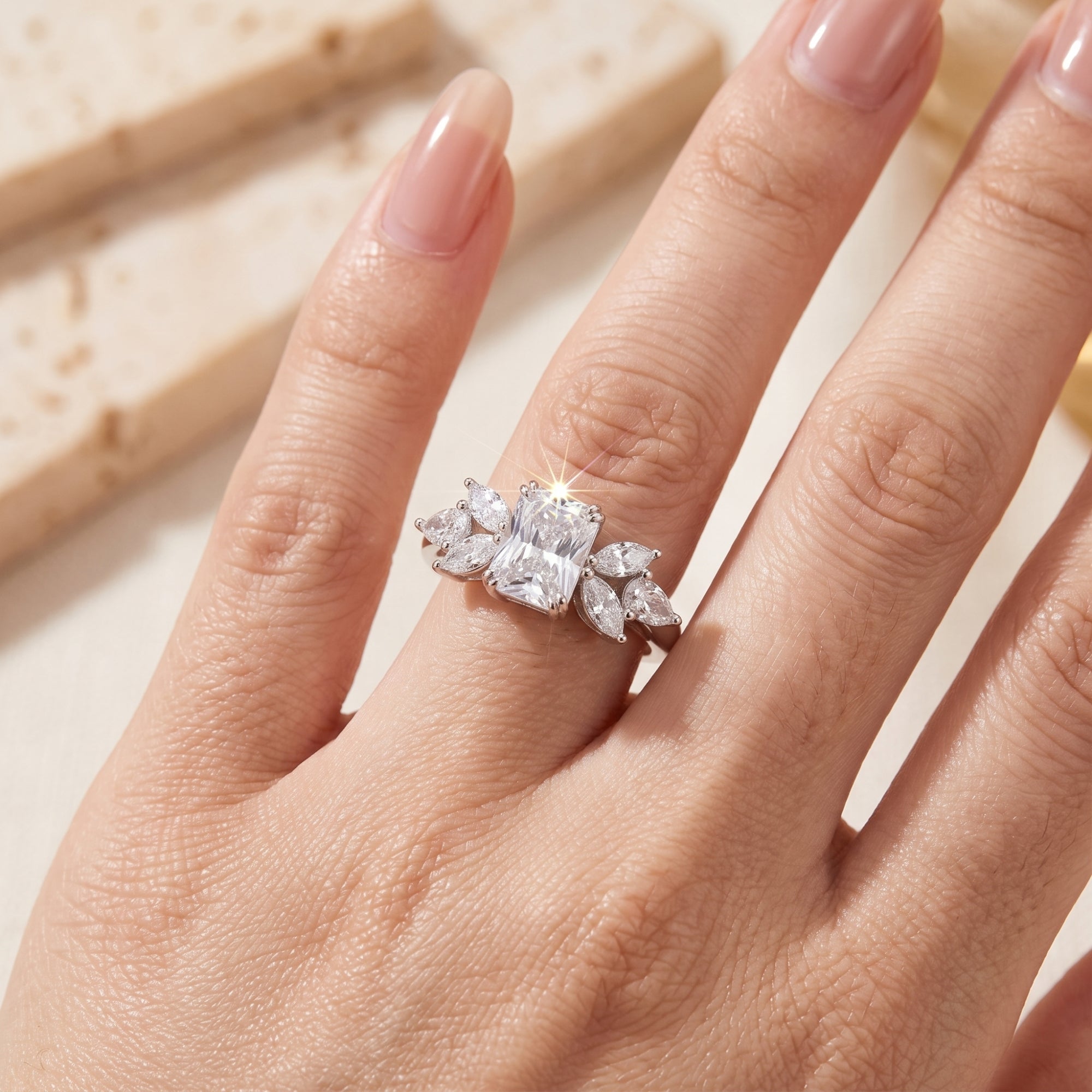 Radiant cut simulated diamond promise ring in sterling silver shown on a finger for scale.