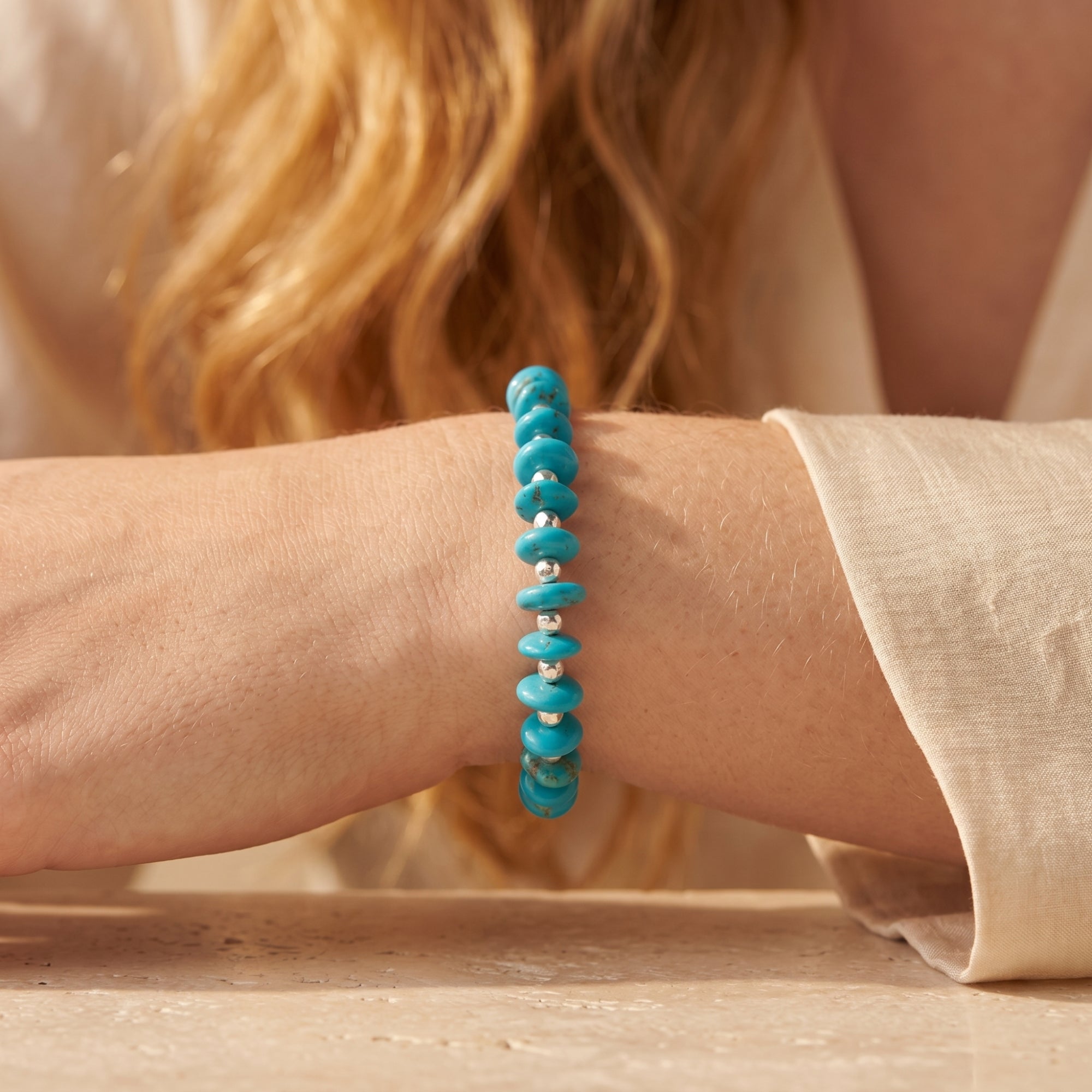 Side view of the Marfa turquoise and sterling silver bead bracelet worn on a model's wrist.