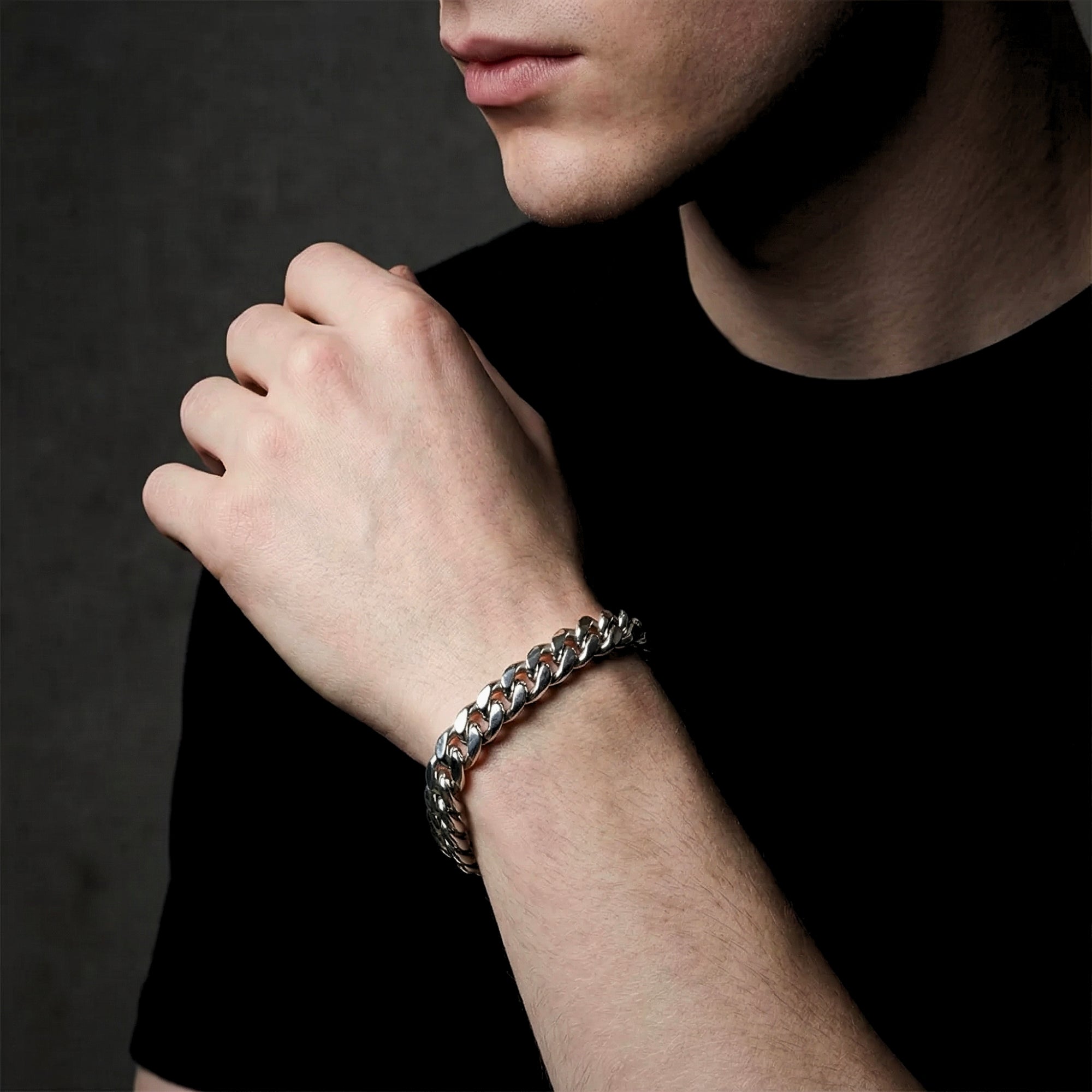 Close-up of a silver 12mm stainless steel Cuban link bracelet on a man's wrist.