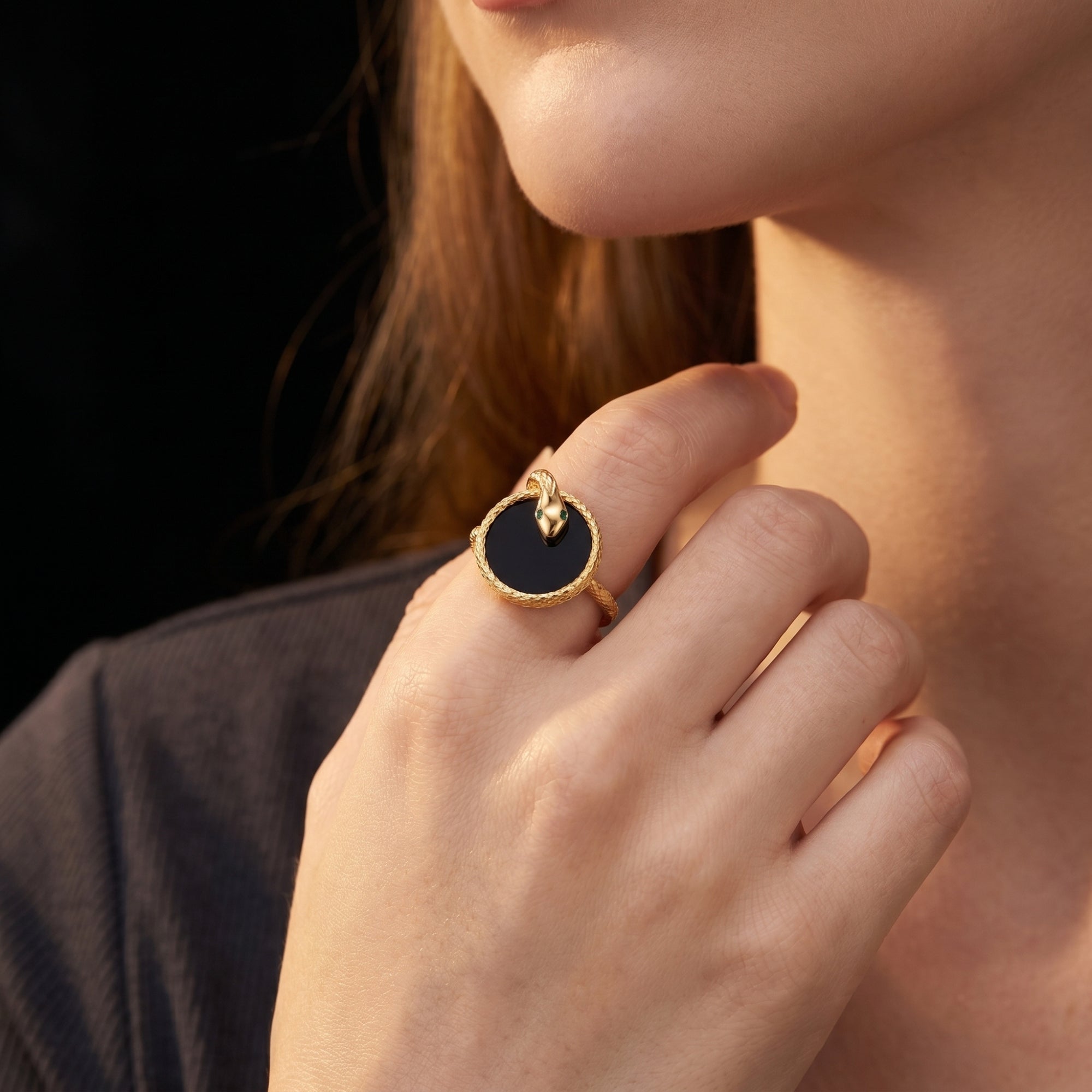 The Regalia onyx statement ring in gold plated silver worn on a model's hand.