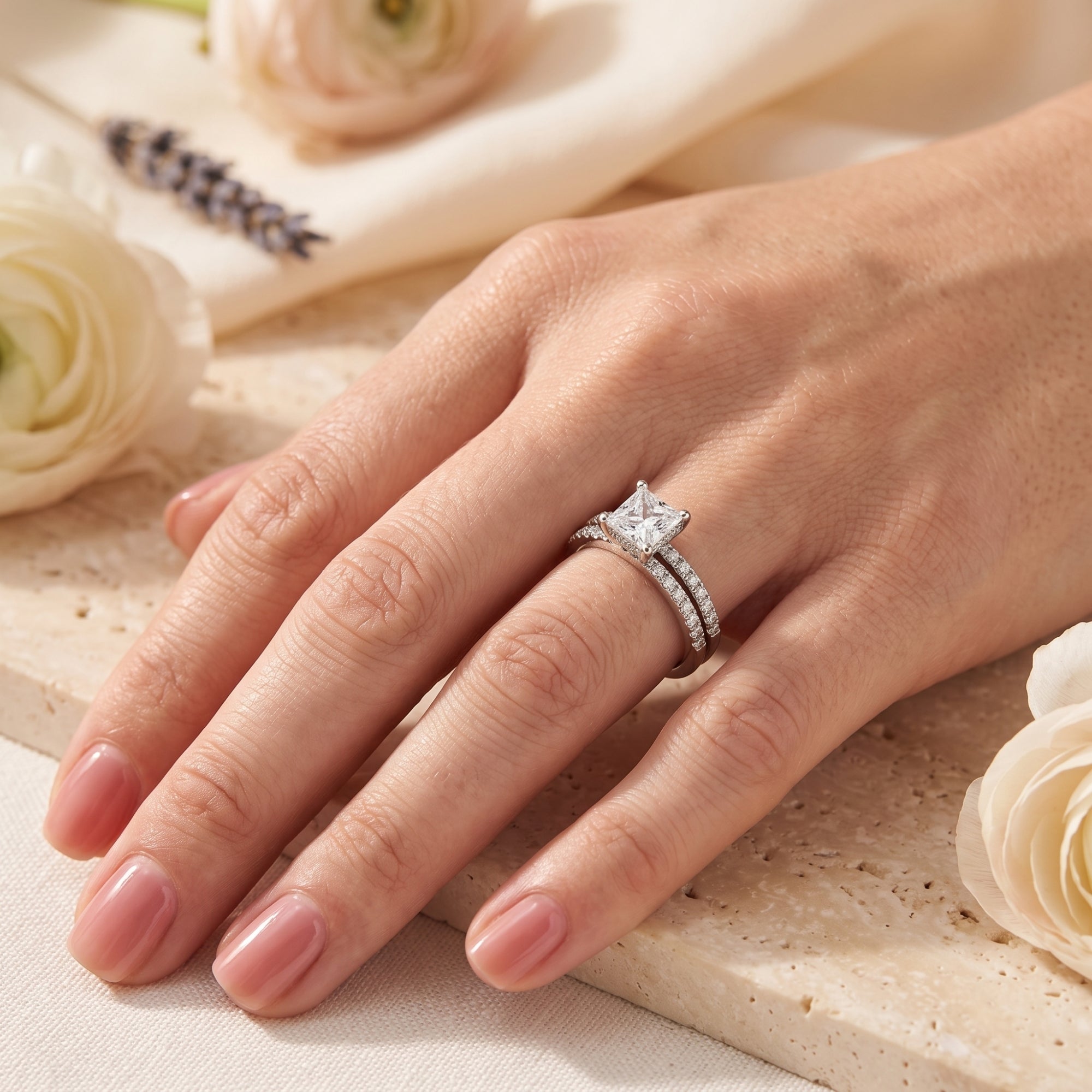 Woman wearing the Alaricia sterling silver ring set with a brilliant square-cut simulated diamond center stone.