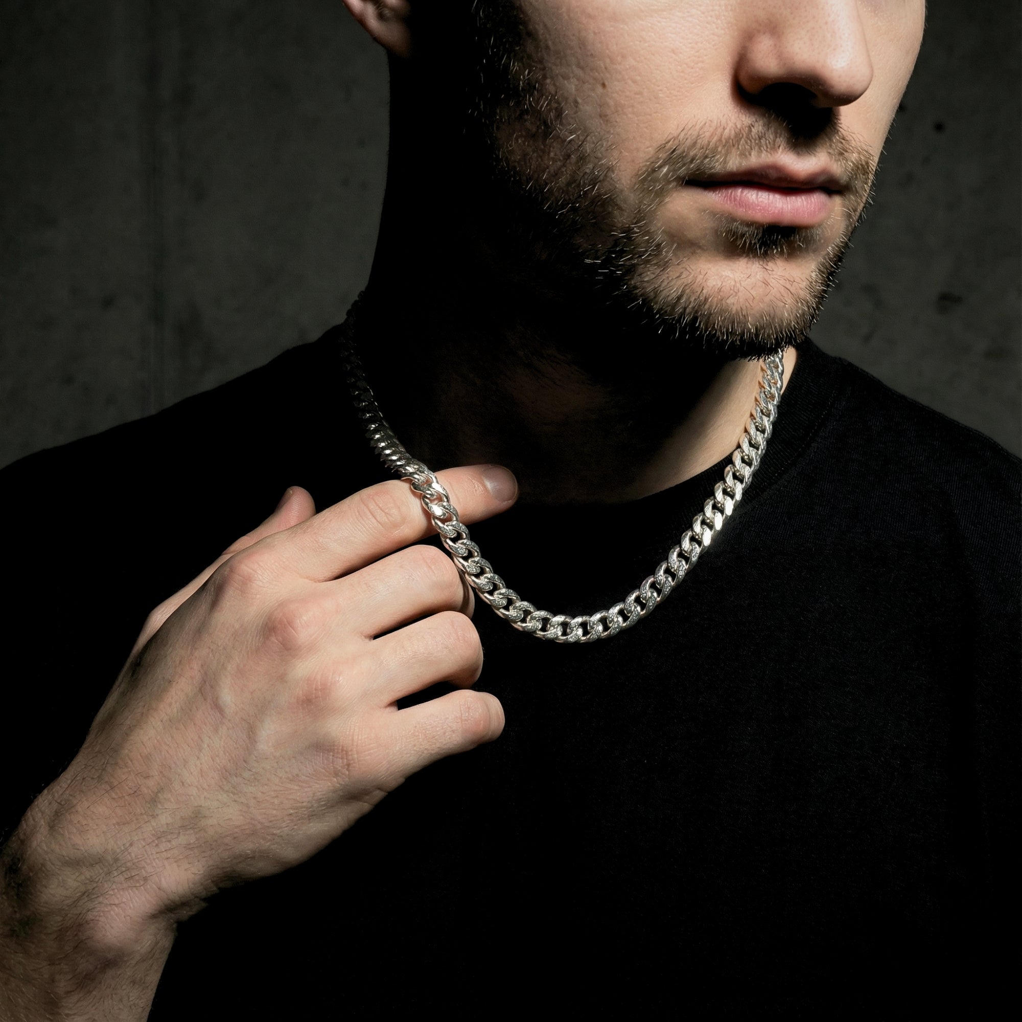 Model holding the silver 8mm stainless steel Cuban link chain to show its scale and thickness.