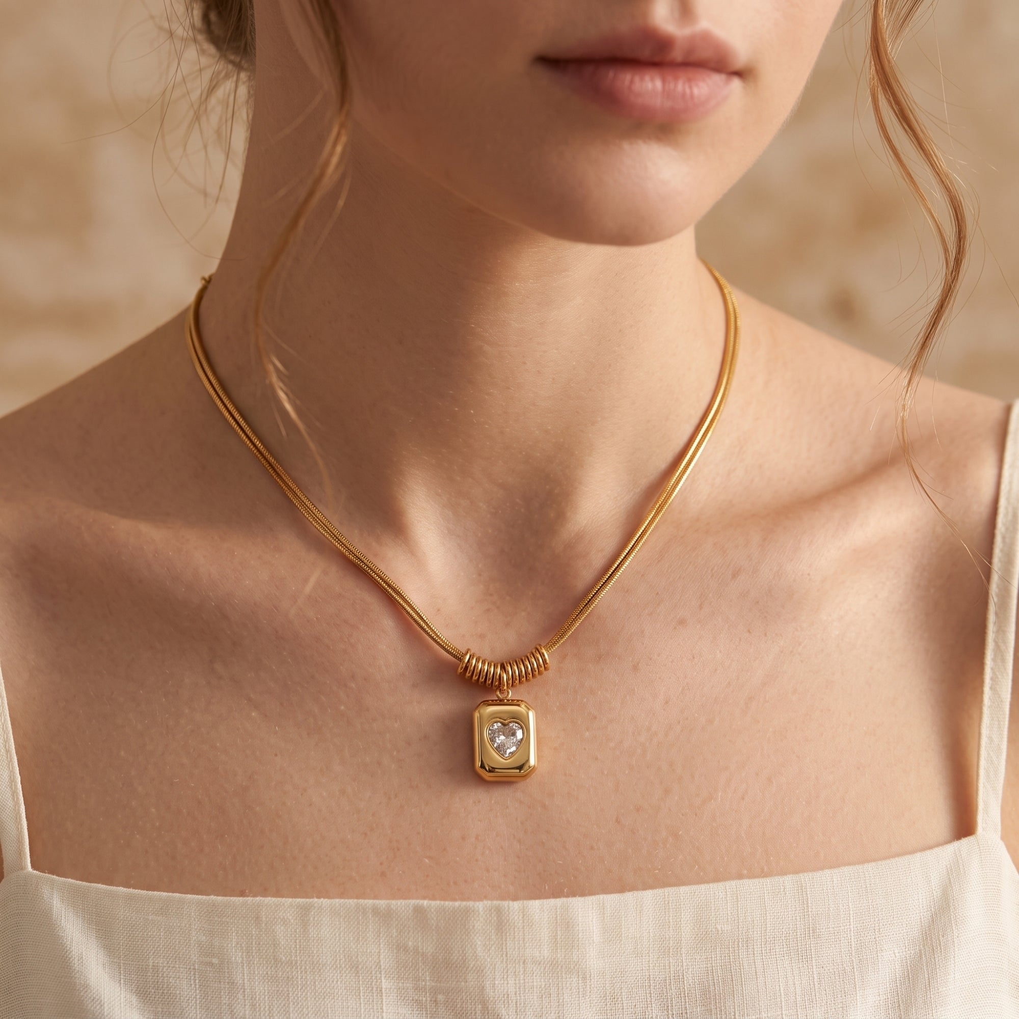 Model wearing the gold Sophia Heart Necklace with a heart-cut simulated diamond pendant.