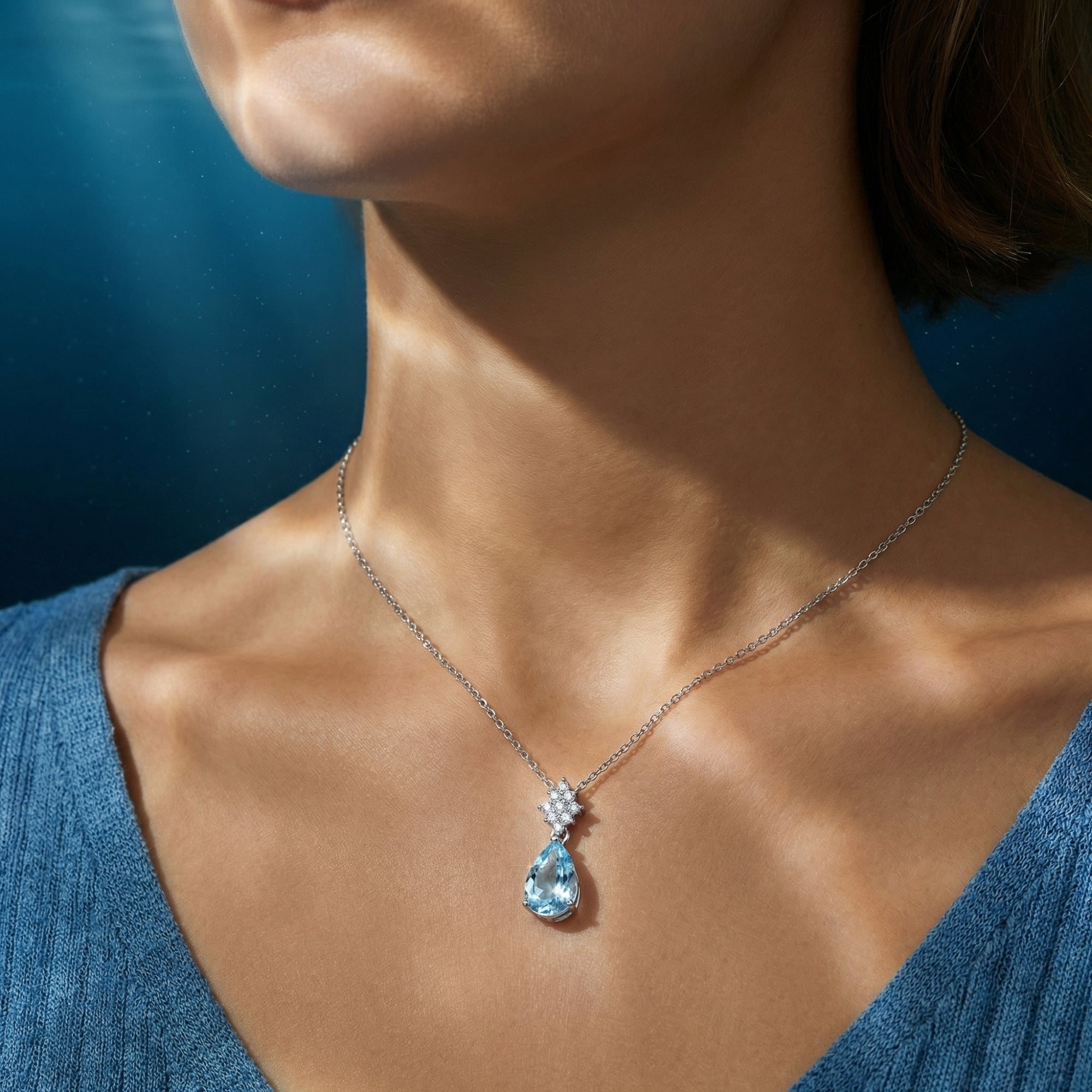 Oceania pear cut aquamarine necklace in platinum worn by a model, highlighting the pendant's oceanic blue color.