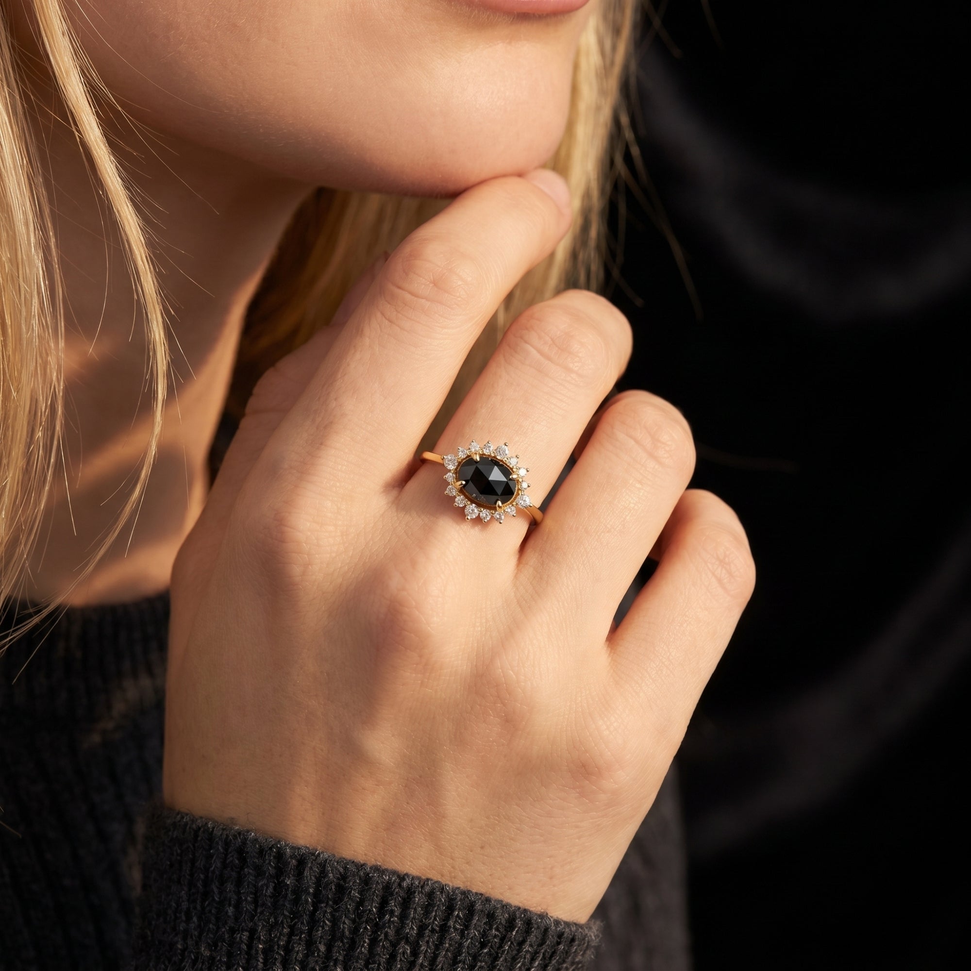Close-up of a model wearing the 18K gold plated Aurelius natural onyx ring with a sparkling halo.