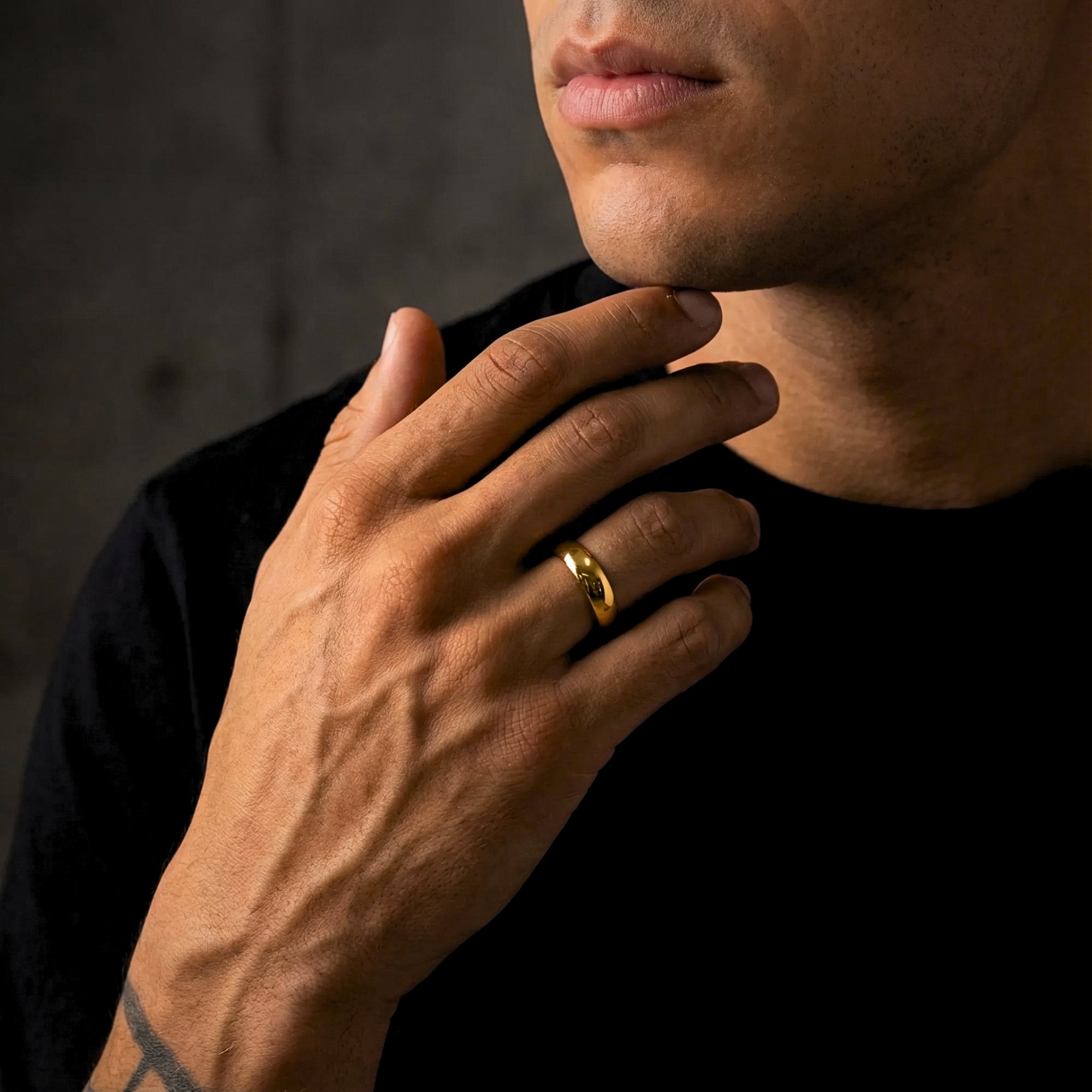 A man wearing the 5mm gold tone stainless steel band ring on his ring finger.