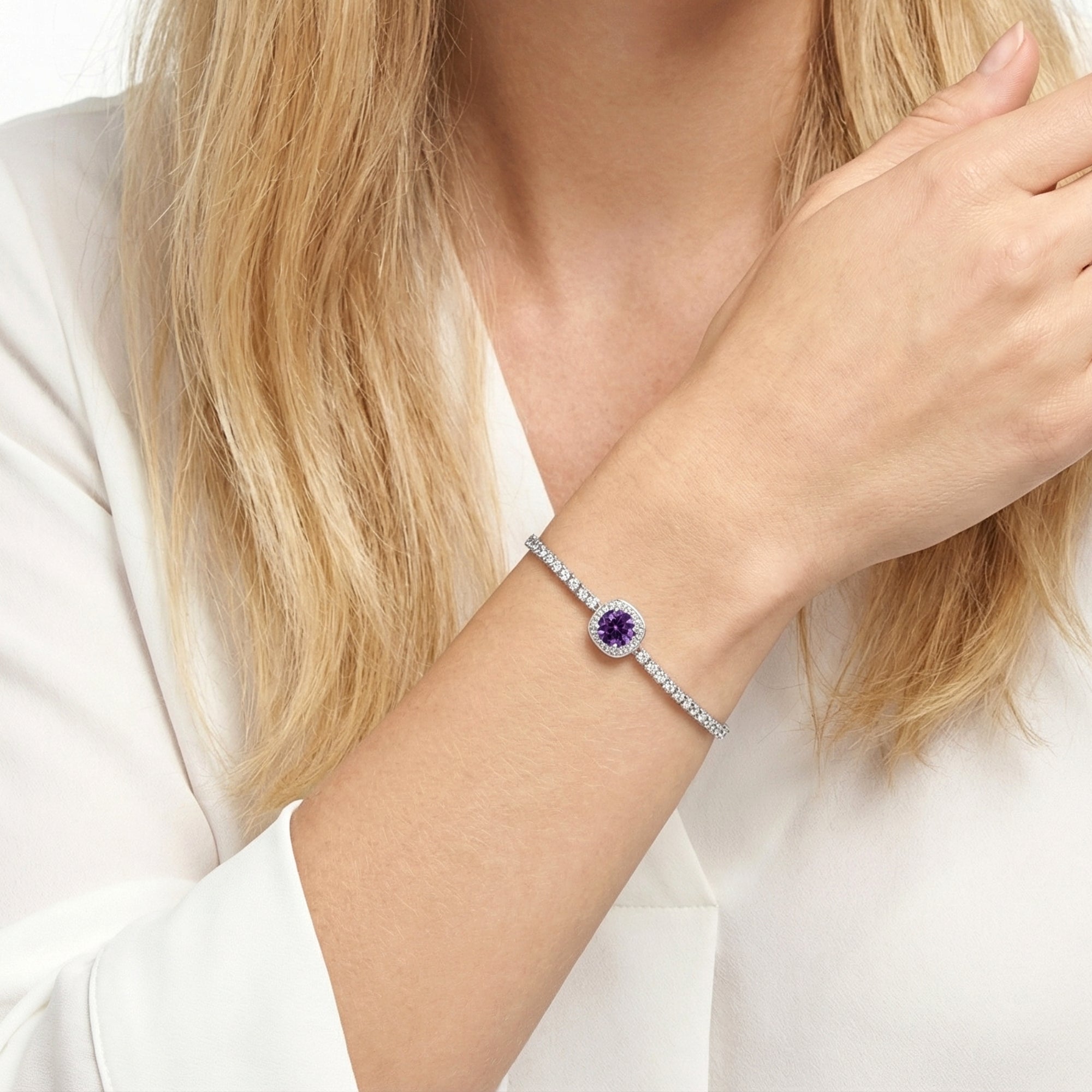 Close-up of the adjustable sterling silver halo bracelet with a round purple simulated amethyst on a model's wrist.