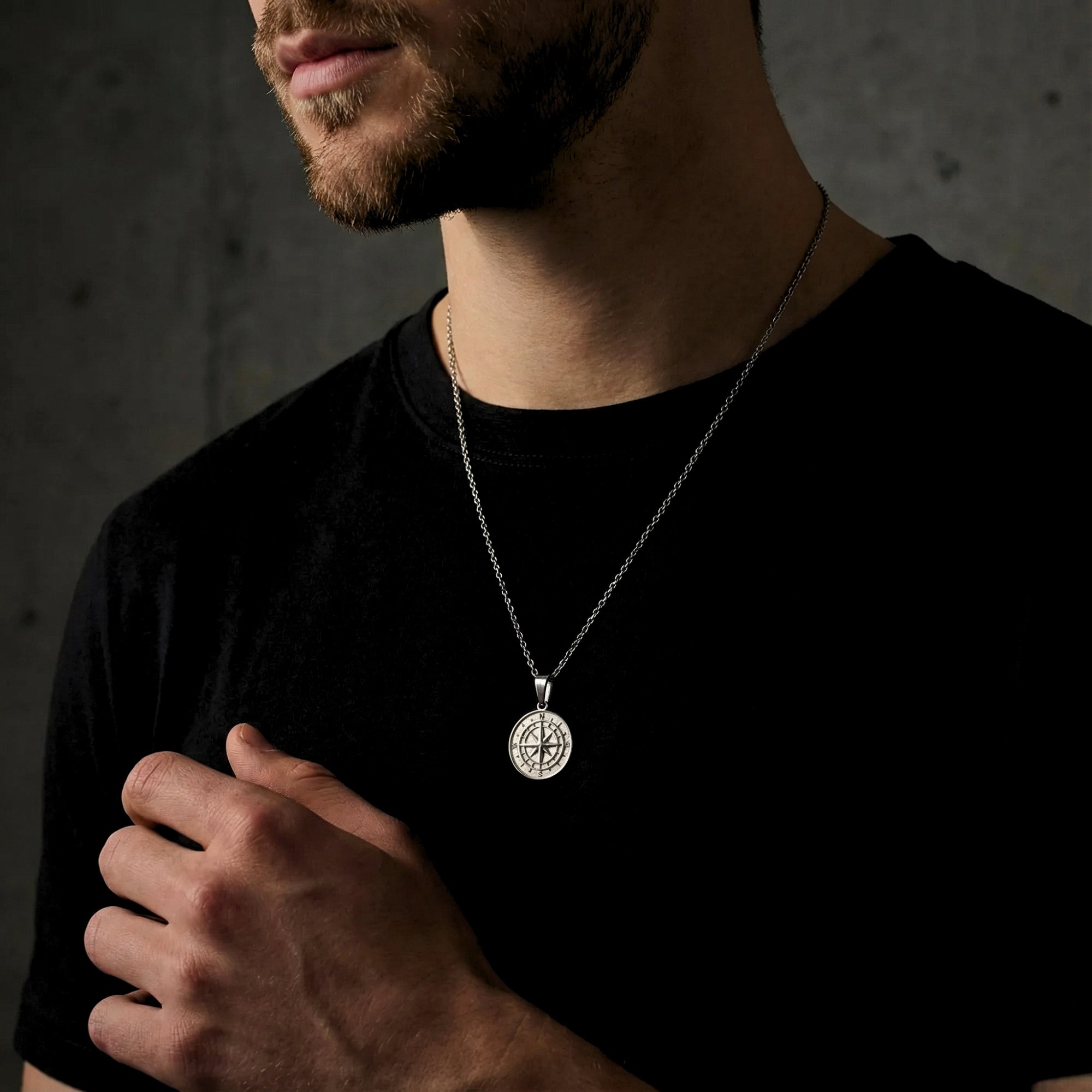Model wearing the silver stainless steel compass pendant necklace, highlighting its masculine design.