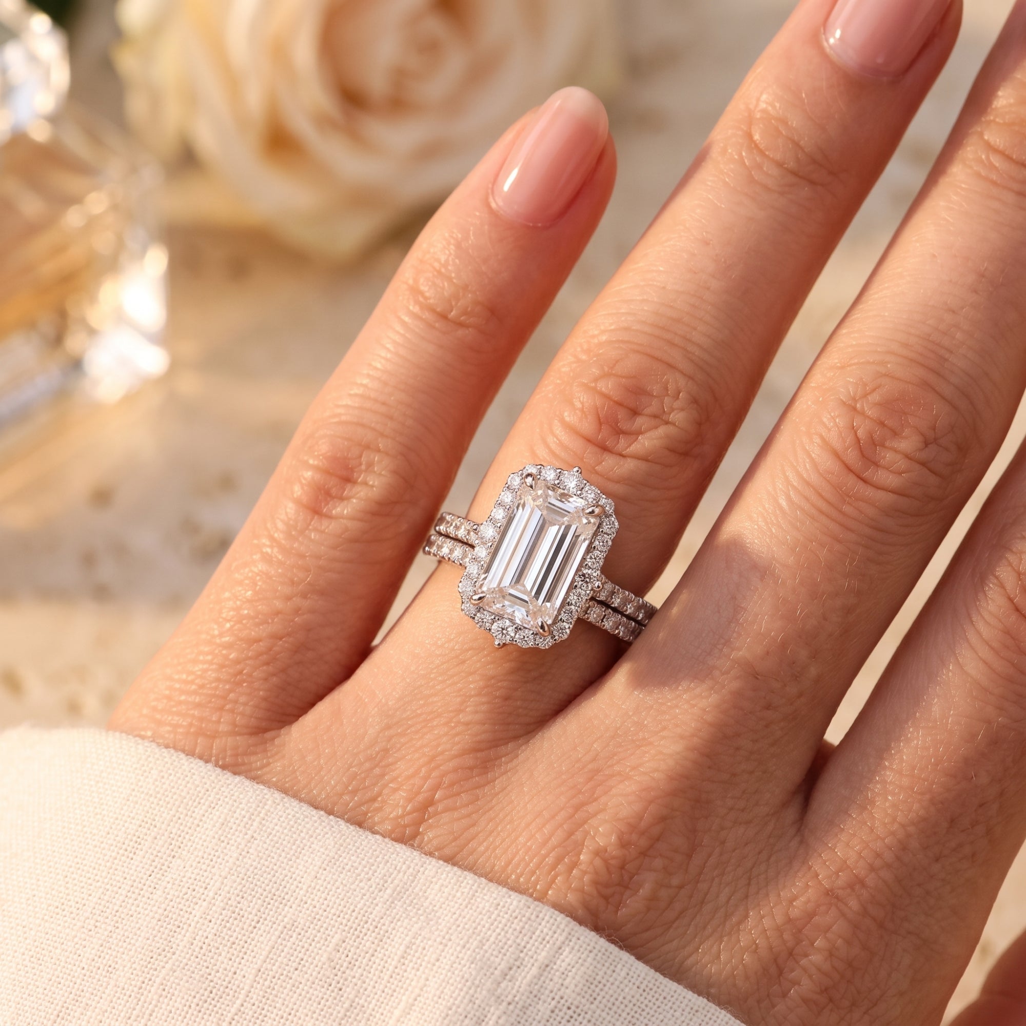 Emerald-cut simulated diamond halo ring set in S925 sterling silver shown on a model's hand.
