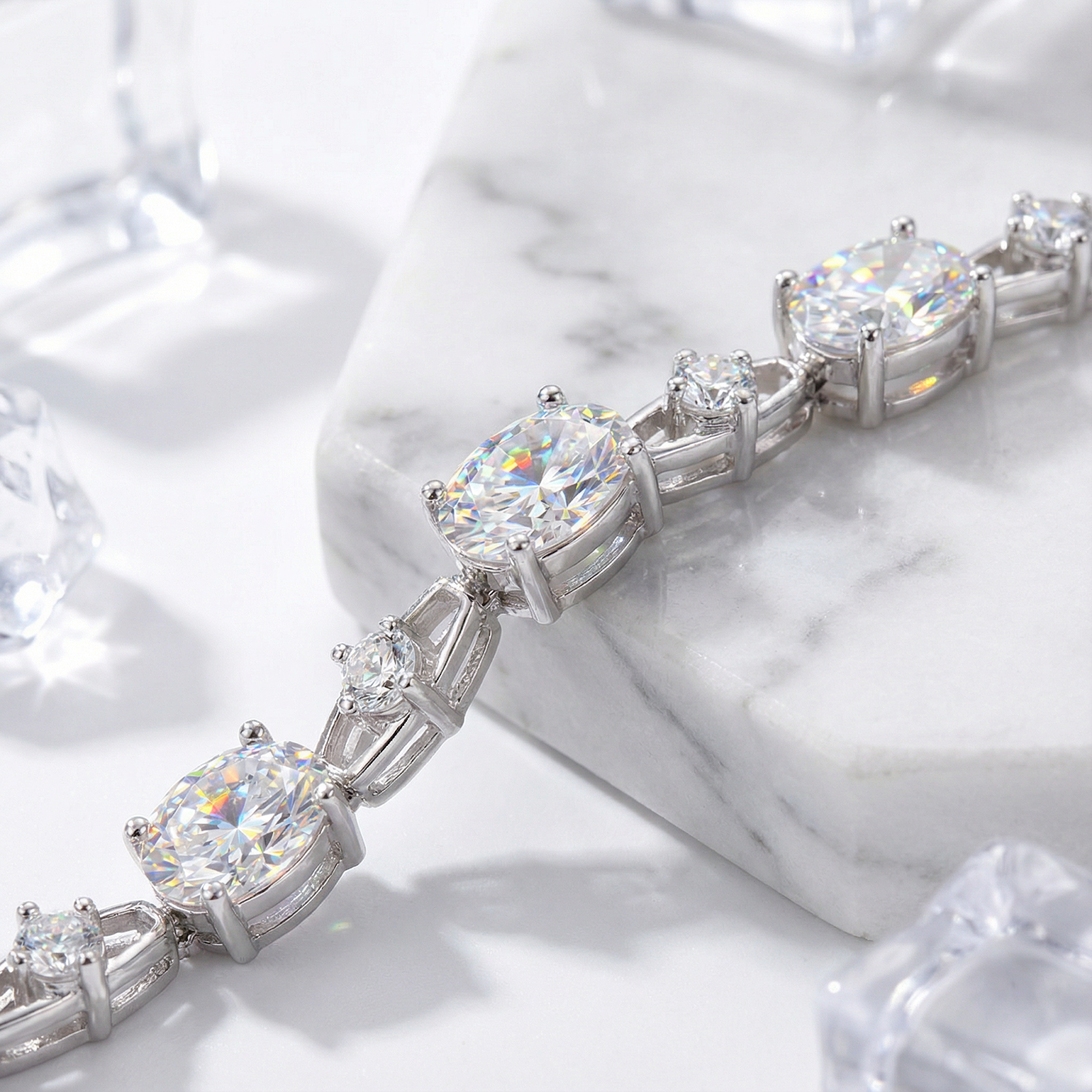 Macro view of oval and round simulated diamonds in a sterling silver setting on marble.