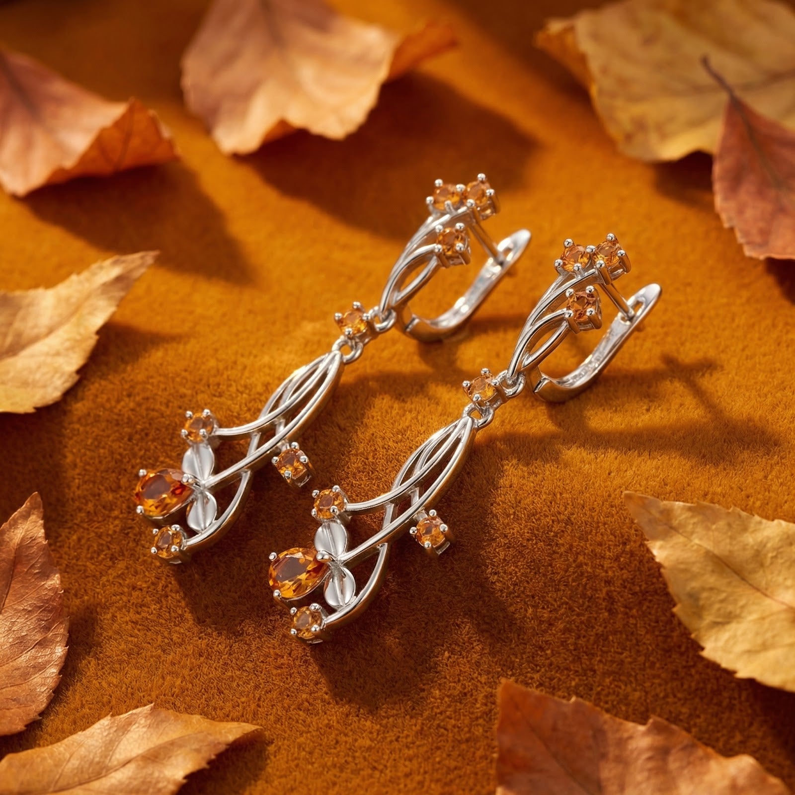 S925 sterling silver vine drop earrings with honey-colored simulated topaz stones on an autumn leaf background.