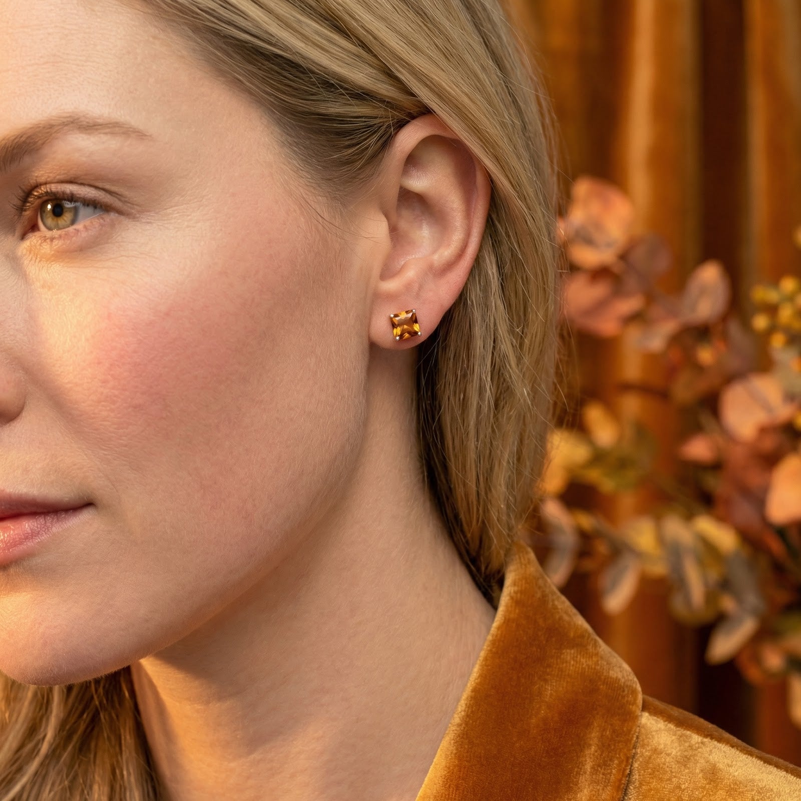 A woman wearing the square-cut simulated topaz stud earrings in 18K rose gold vermeil.