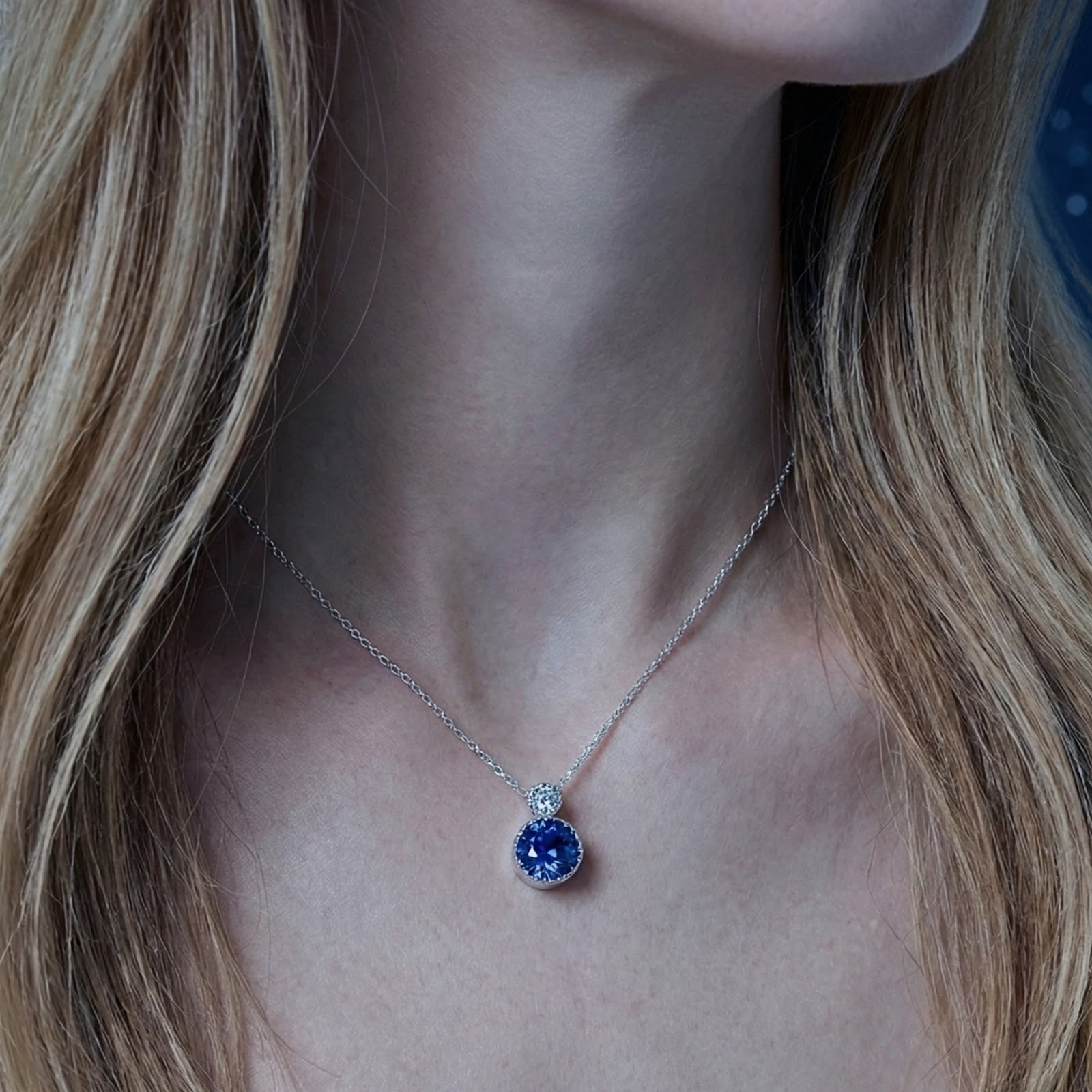 September birthstone simulated sapphire pendant in sterling silver worn on a model's neck.