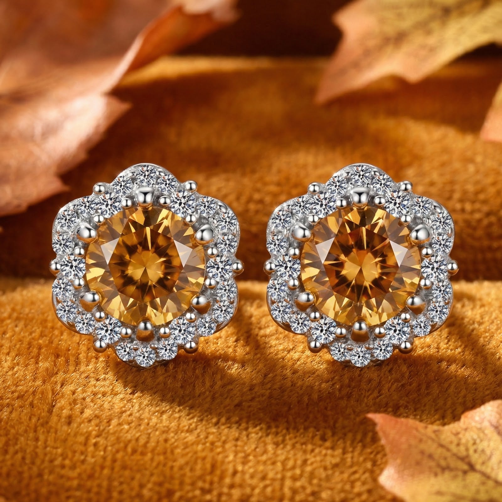 Sterling silver halo stud earrings with round simulated topaz stones on a velvet surface with autumn leaves.
