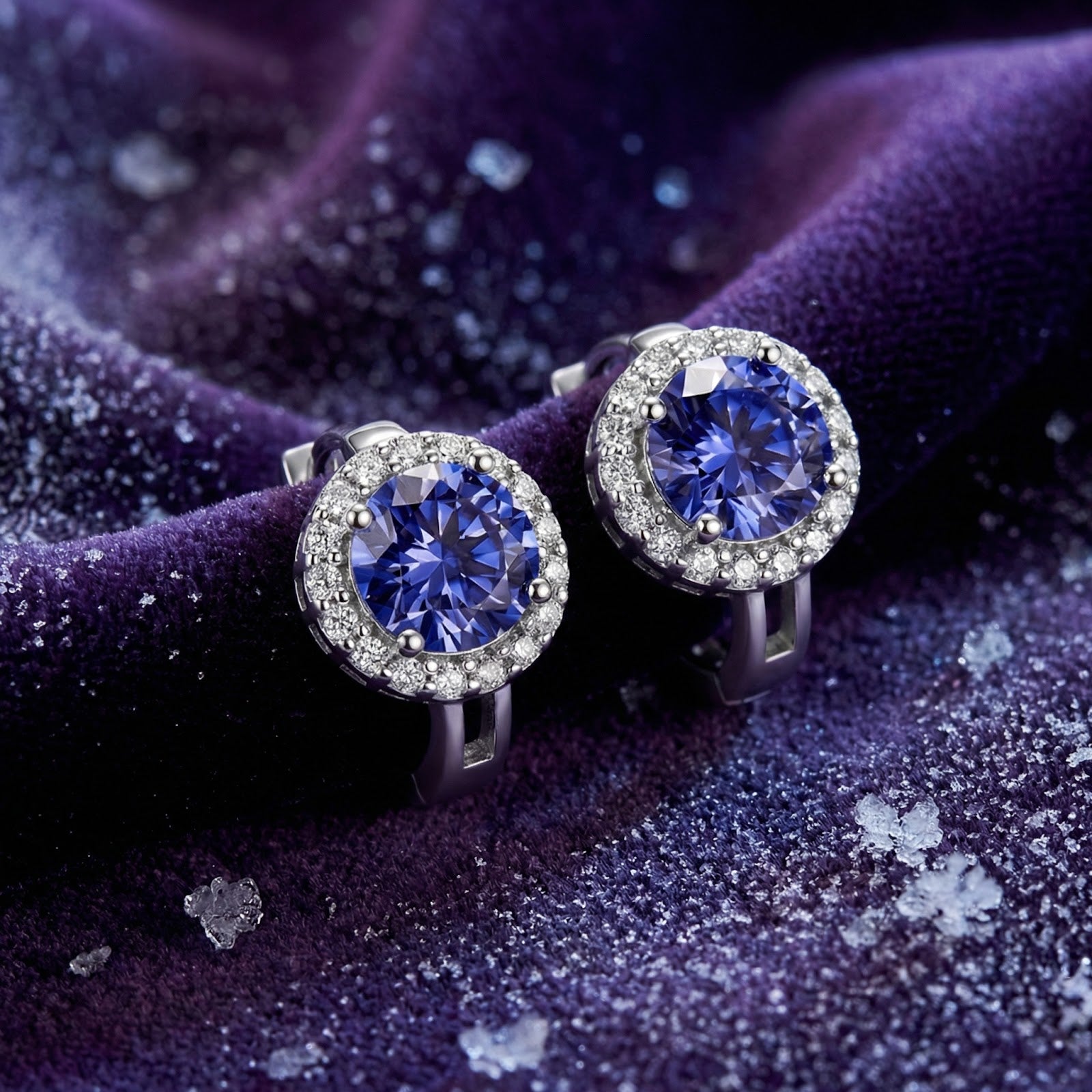 Round cut blue-violet moissanite halo stud earrings in S925 sterling silver on purple velvet with crystal accents.