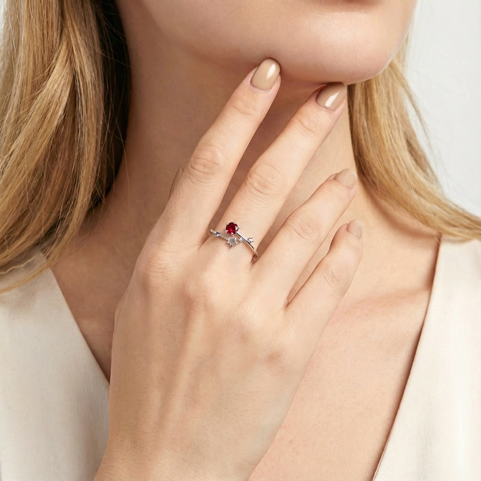 Model wearing the sterling silver Lyriana star ring with a star-cut simulated ruby on her ring finger.