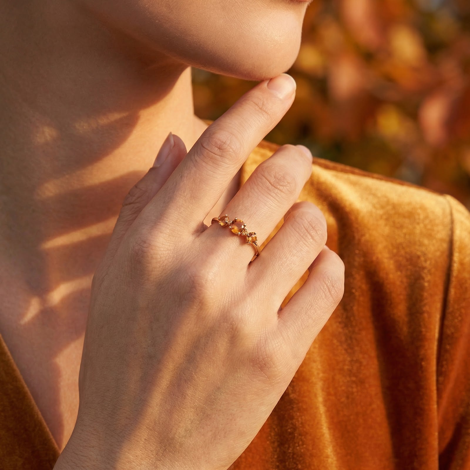 Side view of the 18K gold vermeil Kalisara Row ring with simulated topaz stones worn on a model's hand.
