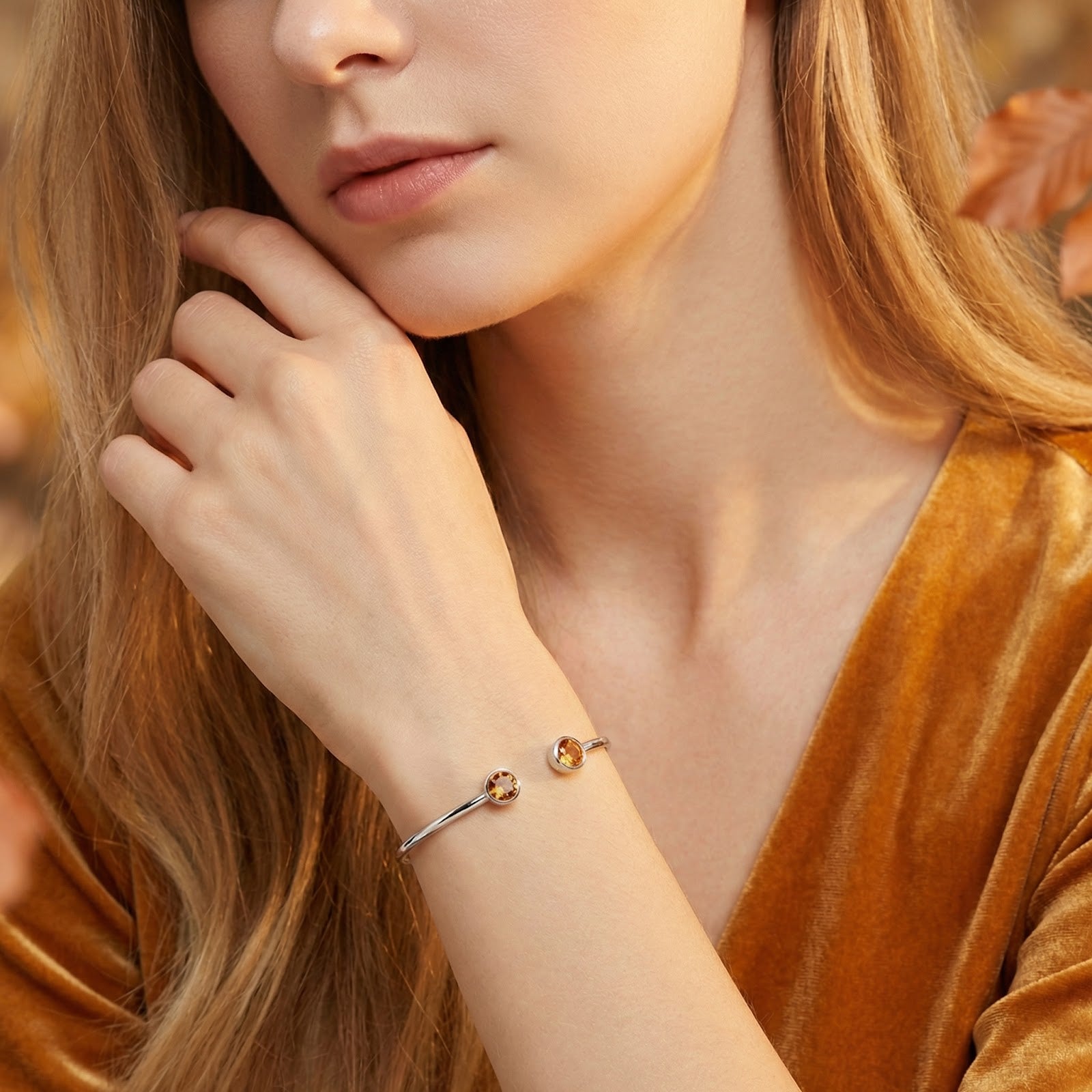 Model wearing the silver stainless steel Vesperelle cuff with round honeyed simulated topaz stones on her wrist.