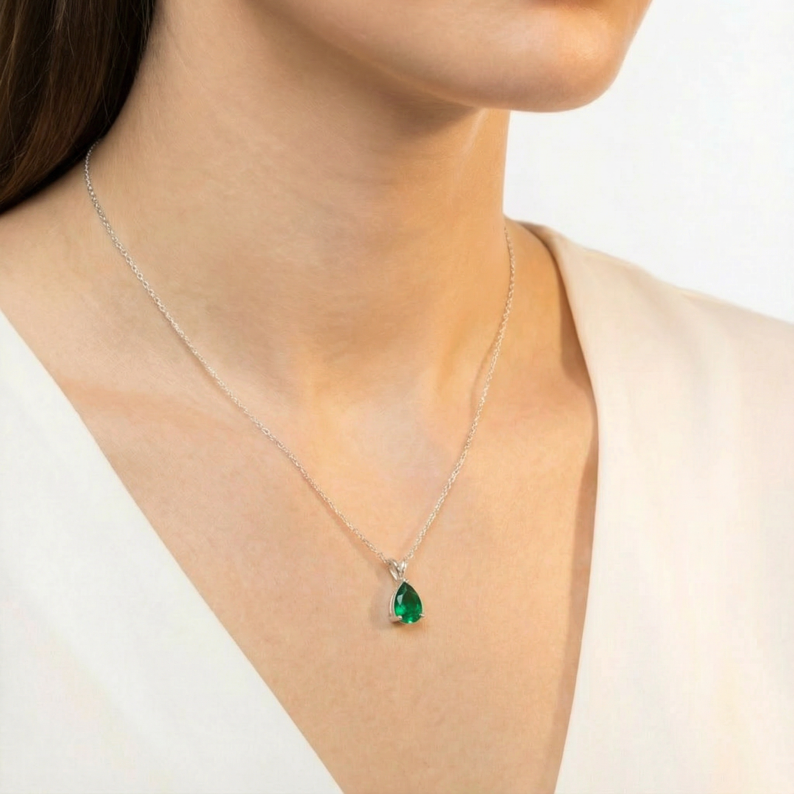 Side view of a model wearing the pear-cut green moissanite birthstone necklace in S925 sterling silver.