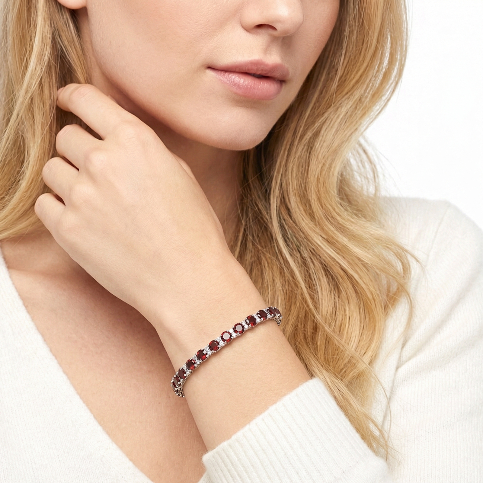 Model wearing the stainless steel Calysto tennis bracelet featuring red simulated garnets on her wrist.