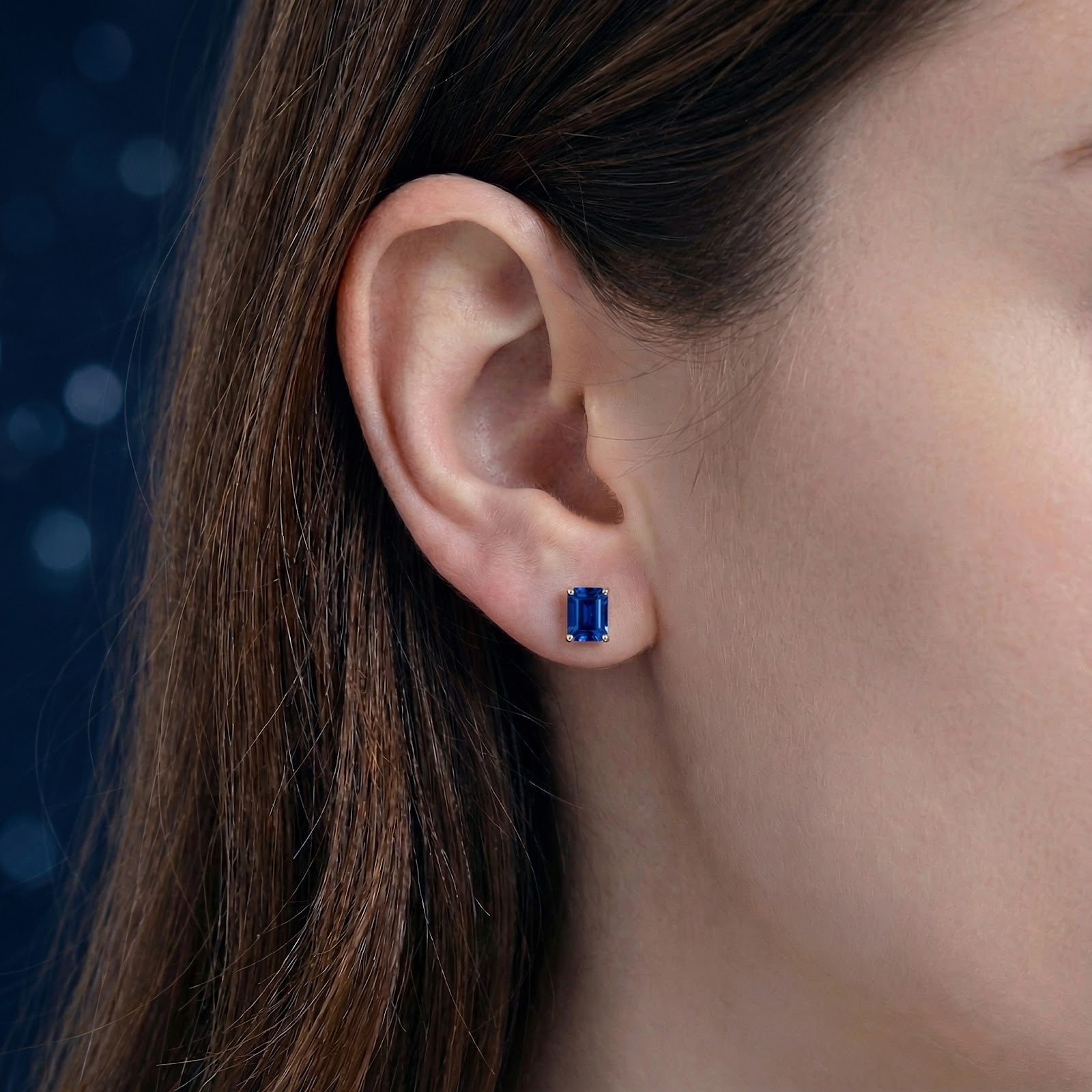 Model wearing a baguette-cut blue simulated sapphire stud earring in 18K gold vermeil.