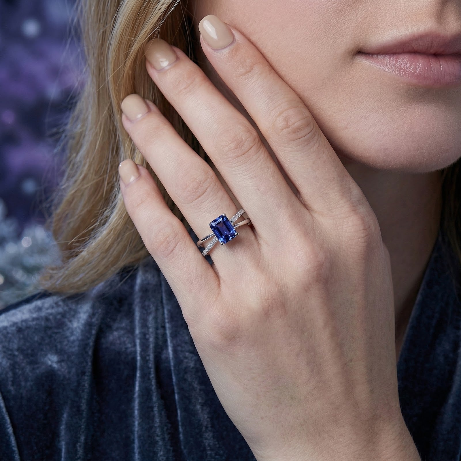 Model wearing the radiant-cut simulated tanzanite ring in sterling silver on her ring finger.