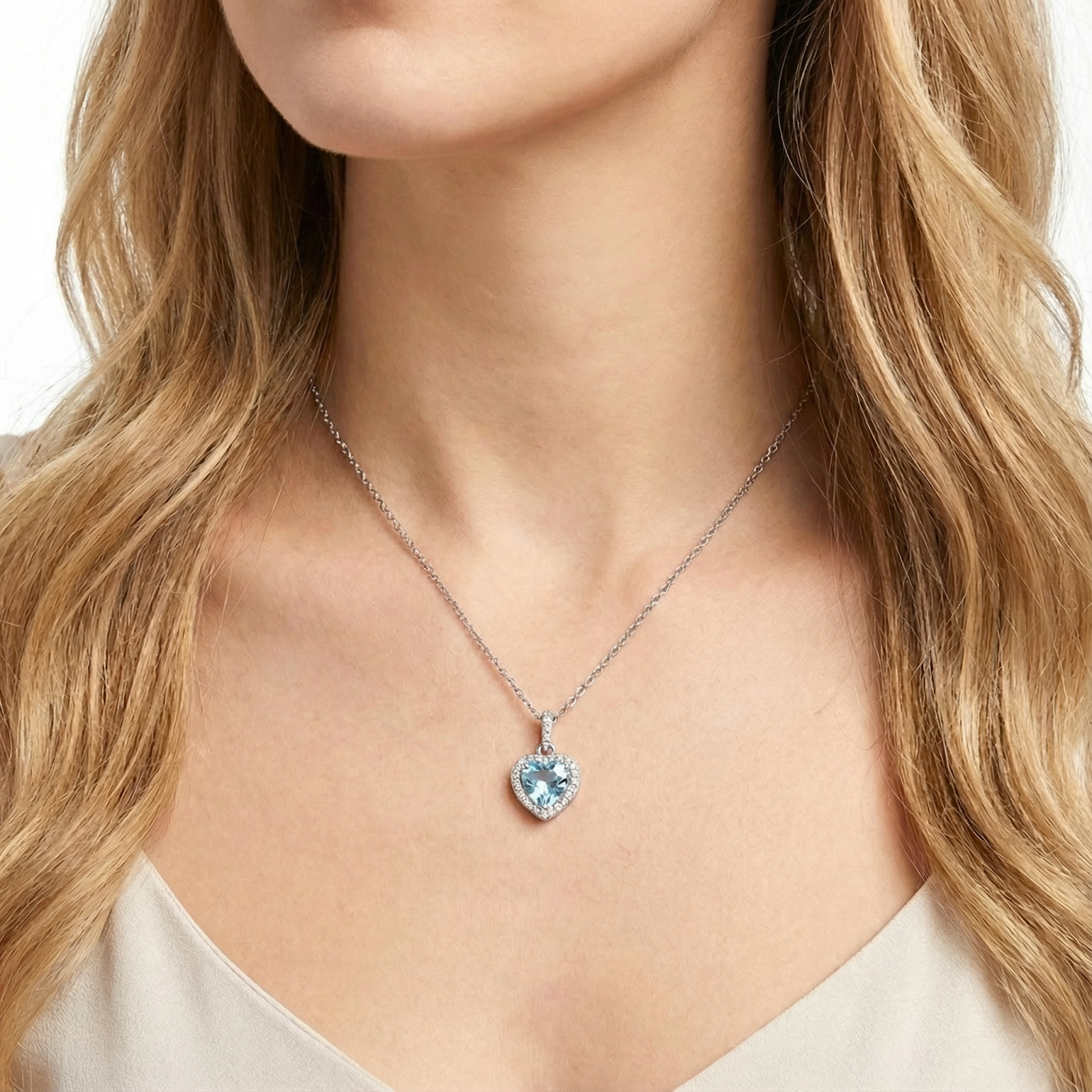 Woman wearing the Nerissa heart cut simulated aquamarine pendant necklace in sterling silver.