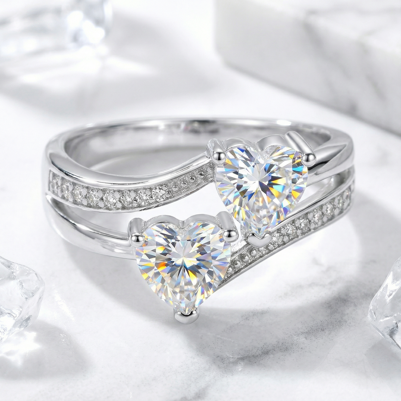 Heart-cut simulated diamond bypass ring in S925 sterling silver, macro view on marble with ice accents.