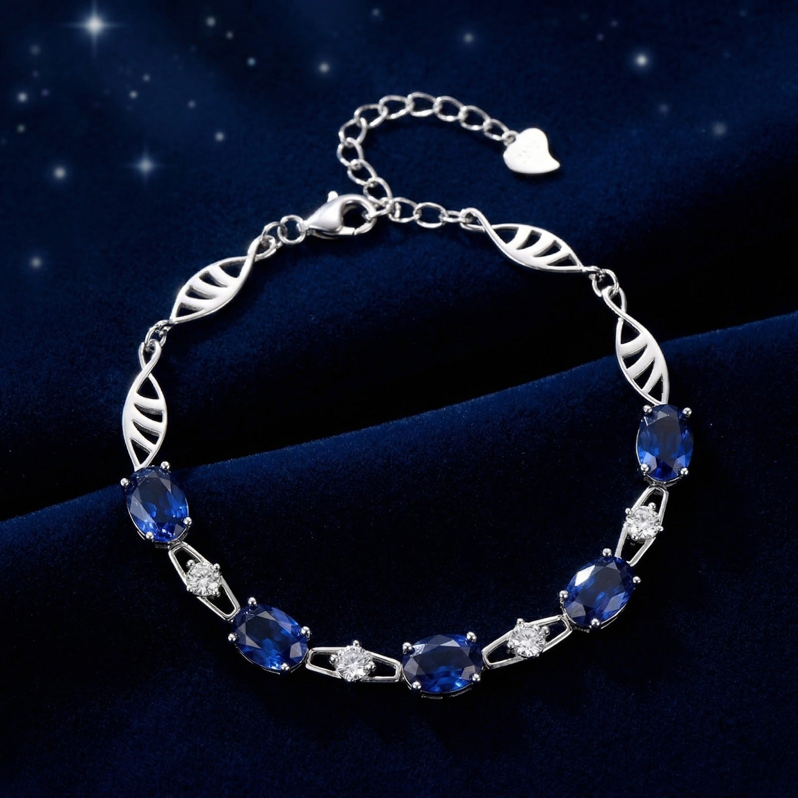 Sterling silver bracelet featuring oval-cut simulated blue sapphires and round accents on a blue velvet background.