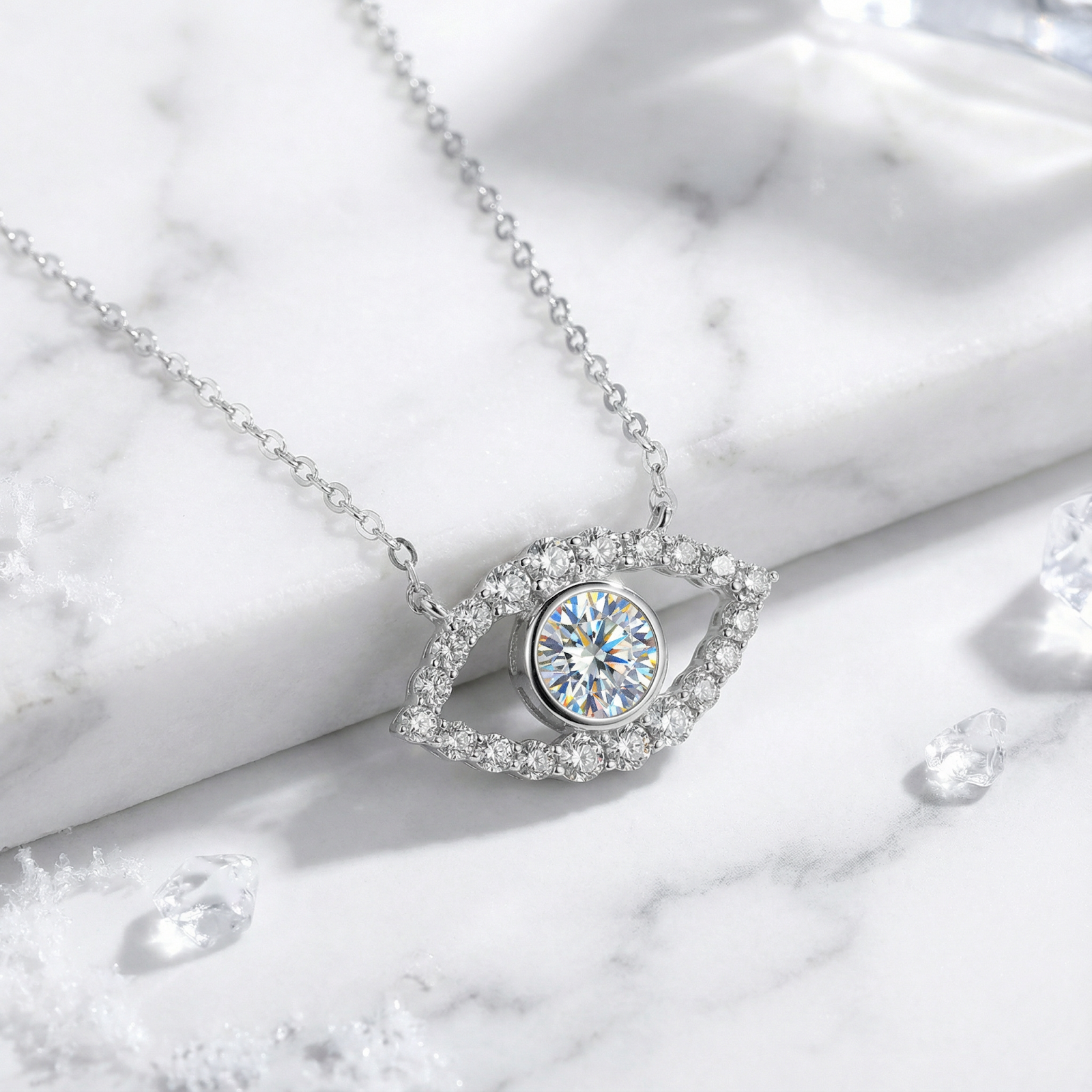 Silver evil eye necklace with a round cut moissanite center stone on a white marble surface.