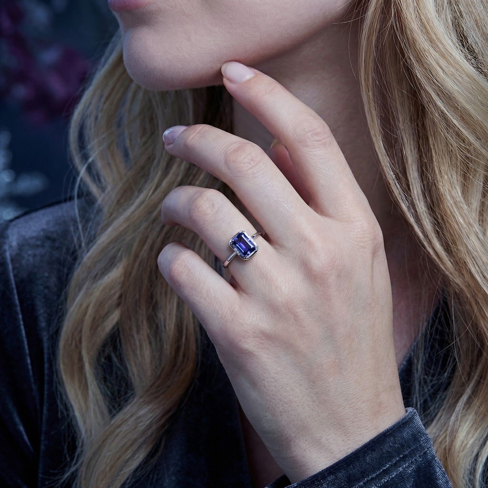 Woman wearing the Elianique emerald-cut simulated tanzanite ring in S925 sterling silver with a velvet dress.
