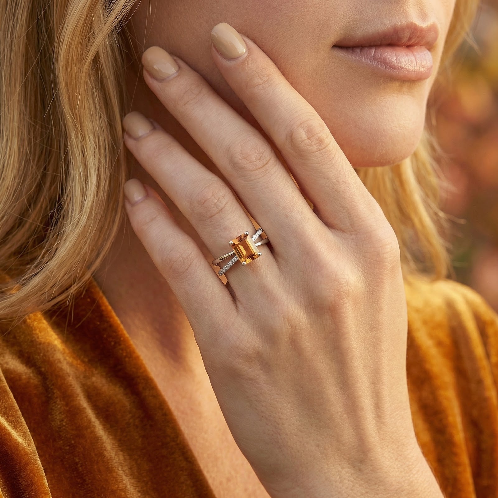 Sterling silver Evelisse twist ring with a radiant-cut simulated topaz worn on a woman's hand near her face.