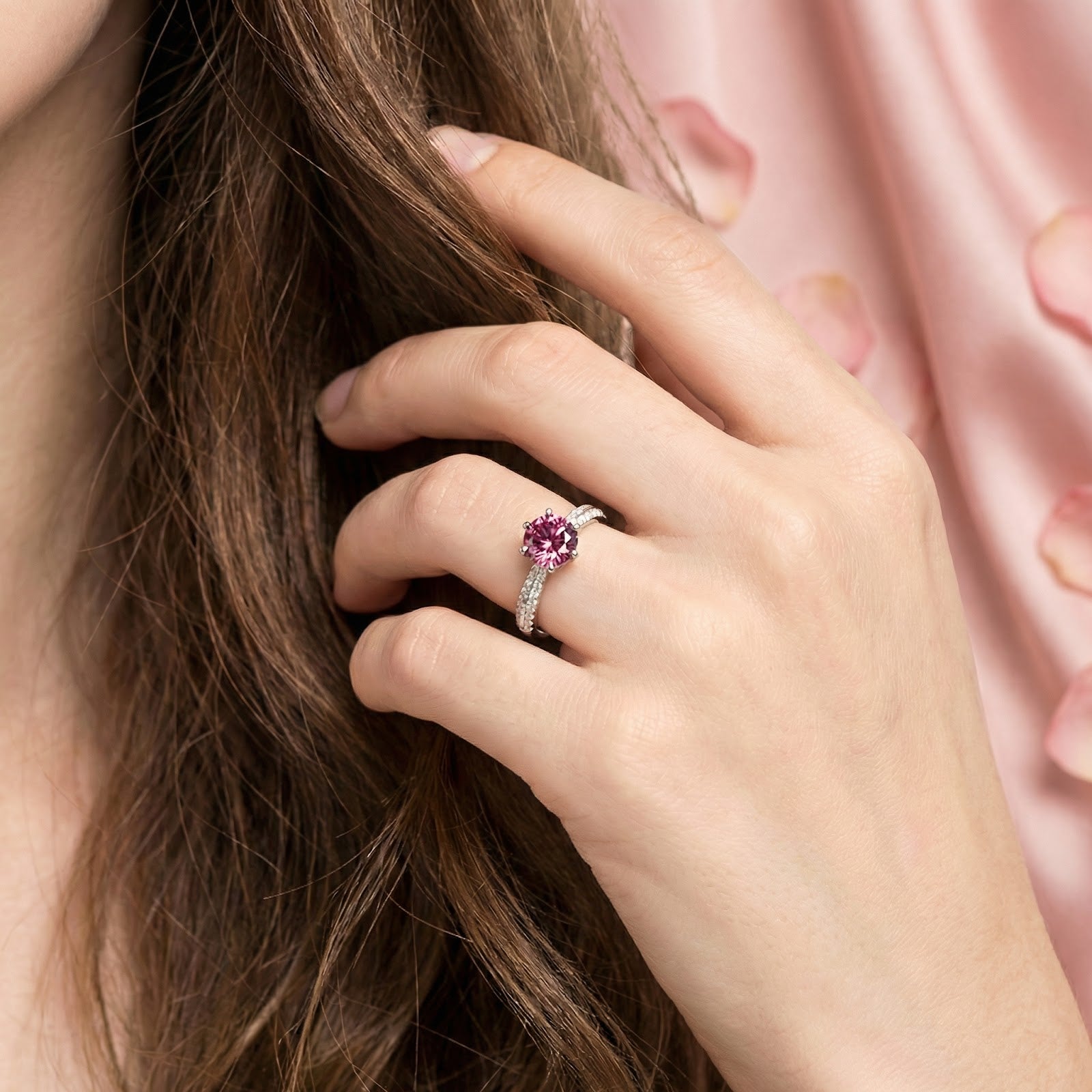 Sterling silver ring with a vivid pink tourmaline stone worn by a model against a soft pink background.