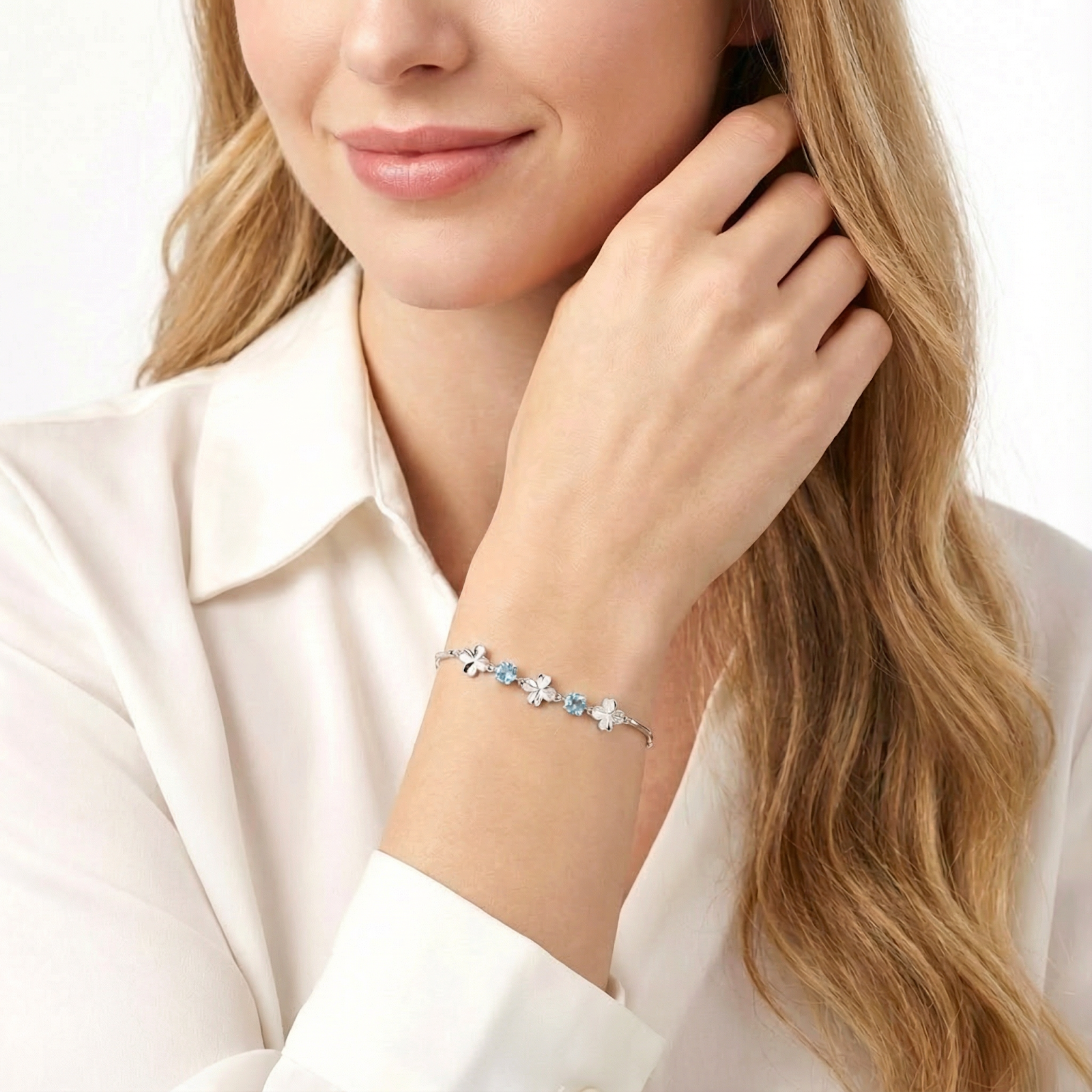 Model wearing the sterling silver Thalina station bracelet with round light blue simulated aquamarine stones.