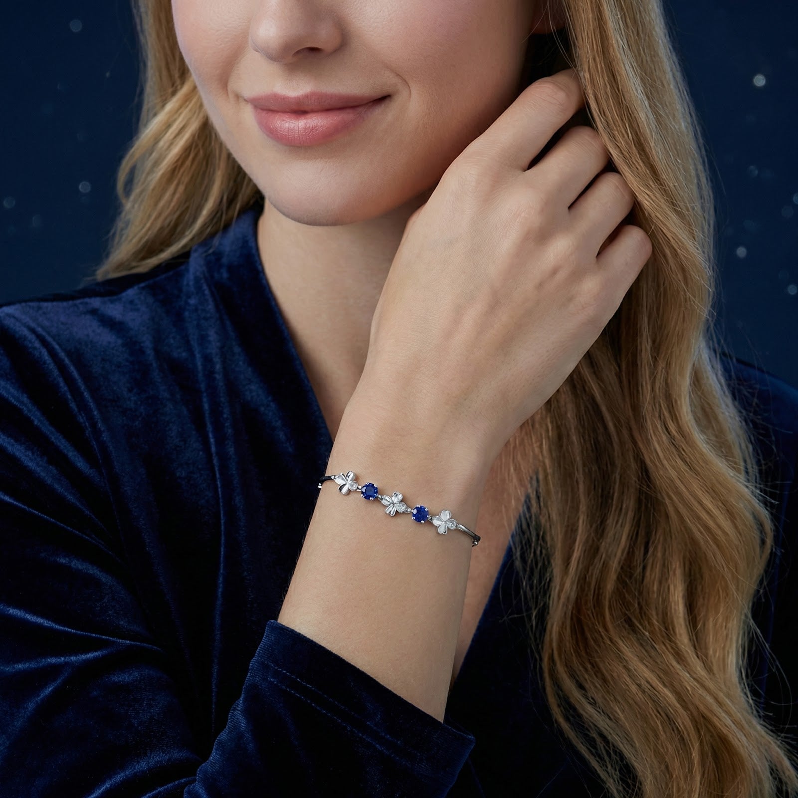 Woman wearing the sterling silver clover bracelet with blue simulated sapphires on her wrist.