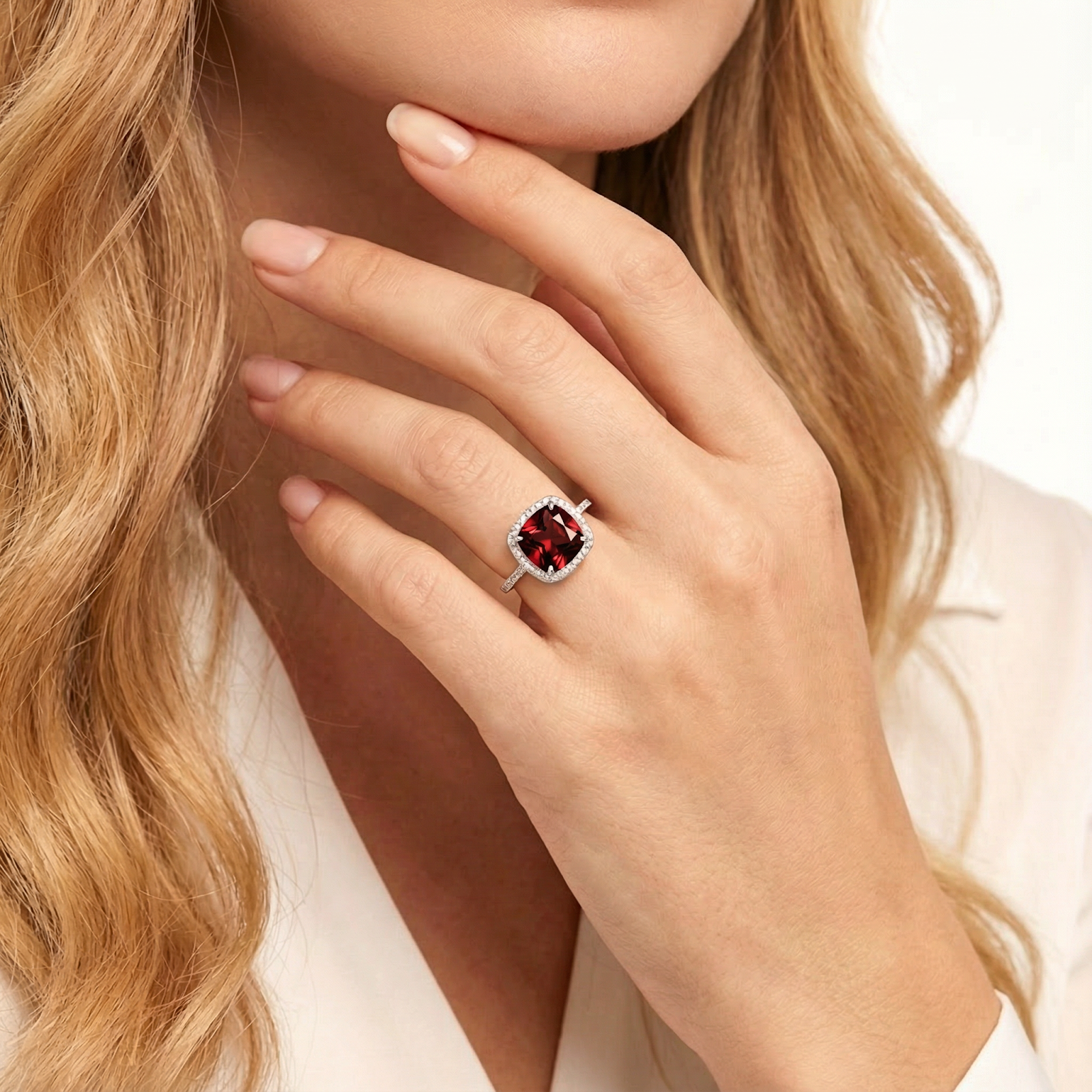 Blonde model wearing the cushion cut simulated garnet sterling silver ring on her ring finger.