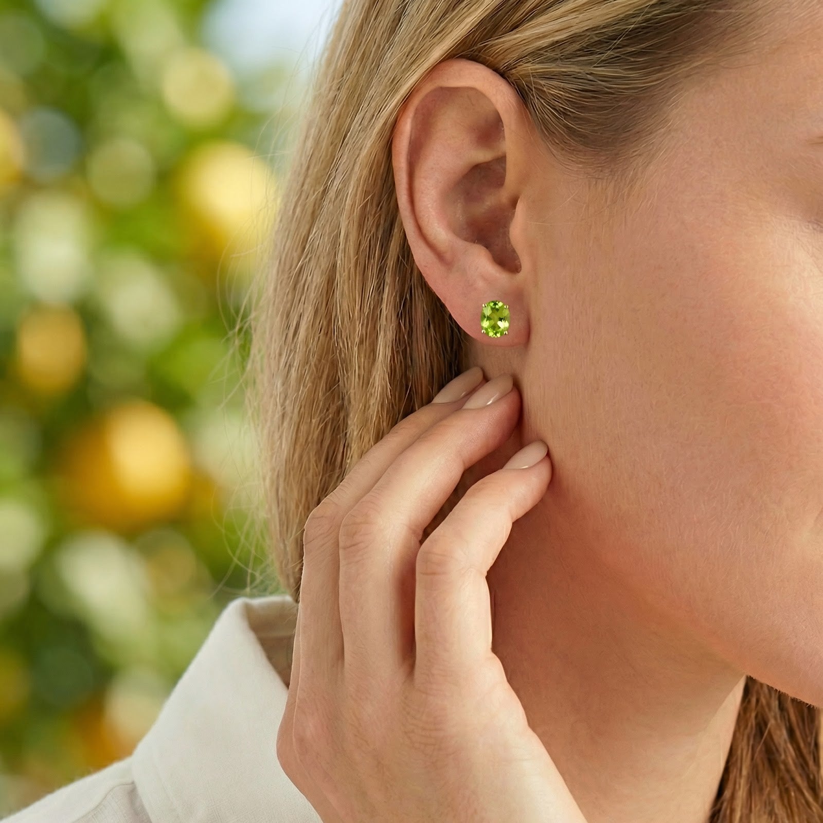 Green simulated peridot stud earring in 18K gold vermeil worn on a model's ear.
