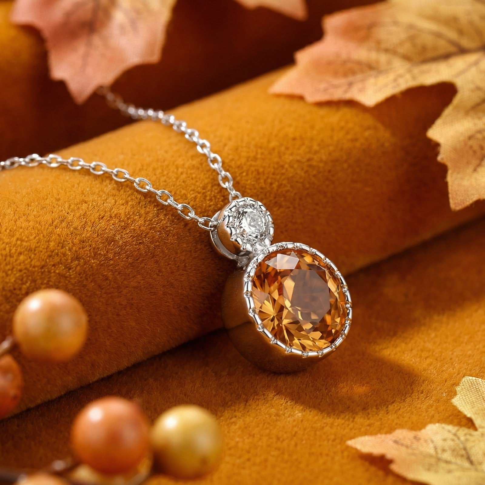 Round-cut simulated topaz necklace in sterling silver on an autumn-themed lifestyle background.