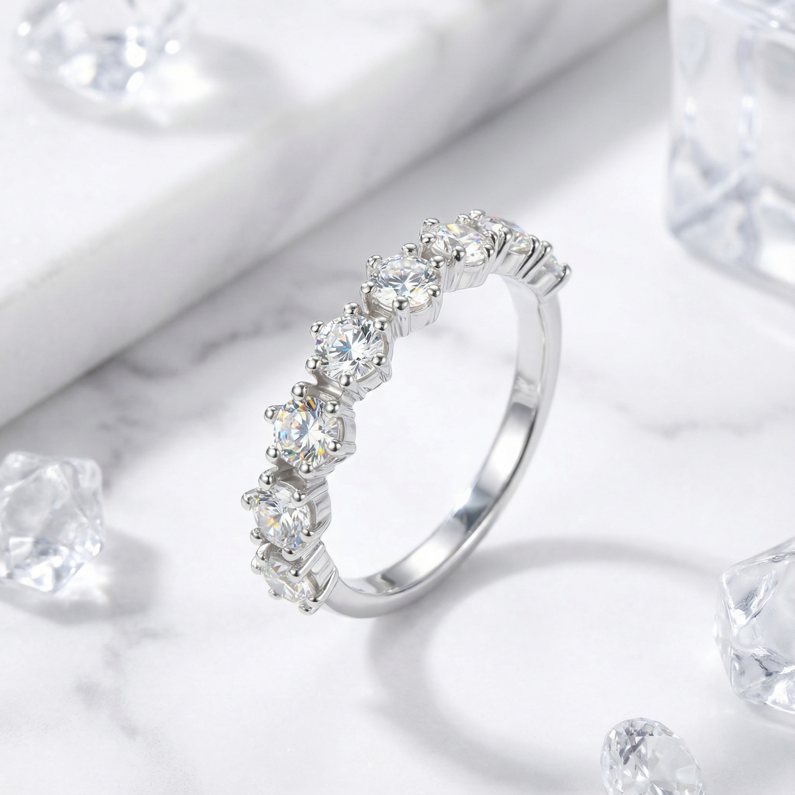 Angled view of the Lucianne S925 sterling silver ring with round-cut simulated diamonds on a marble background.