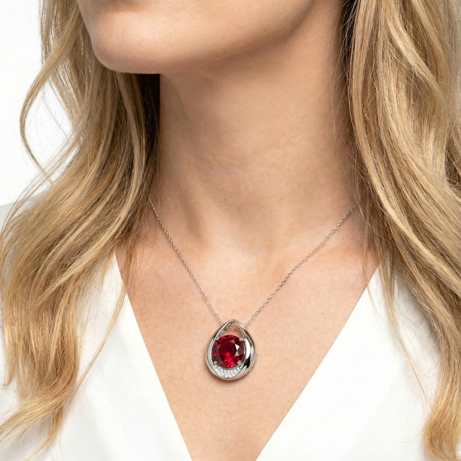 Model wearing the Ariselle pear-shaped sterling silver necklace with a round simulated ruby pendant.