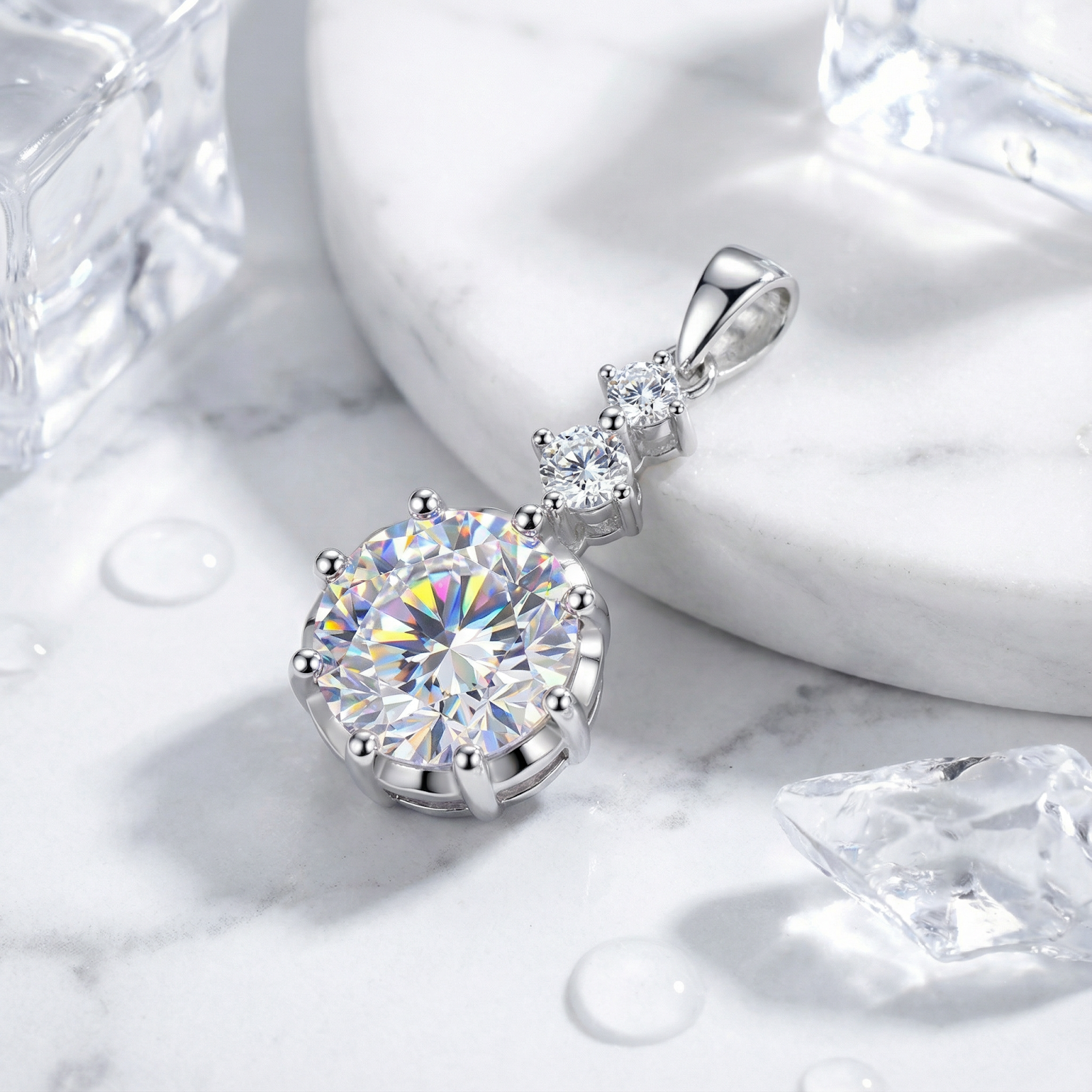 Sterling silver Aurelle Drop pendant with graduated round-cut simulated diamonds shown on a marble surface.