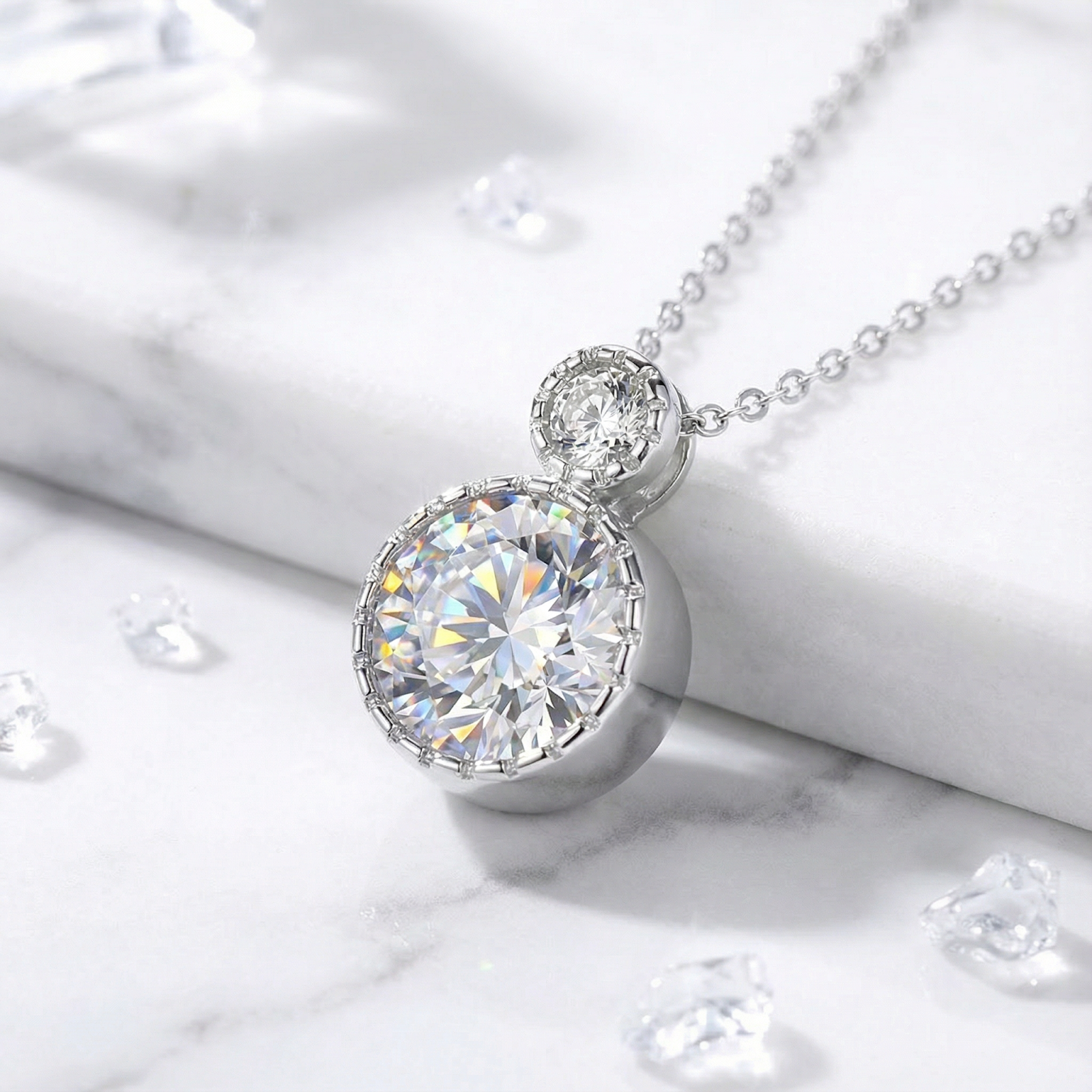 Frontal view of the sterling silver Luciana necklace with round-cut simulated diamonds on a marble surface.